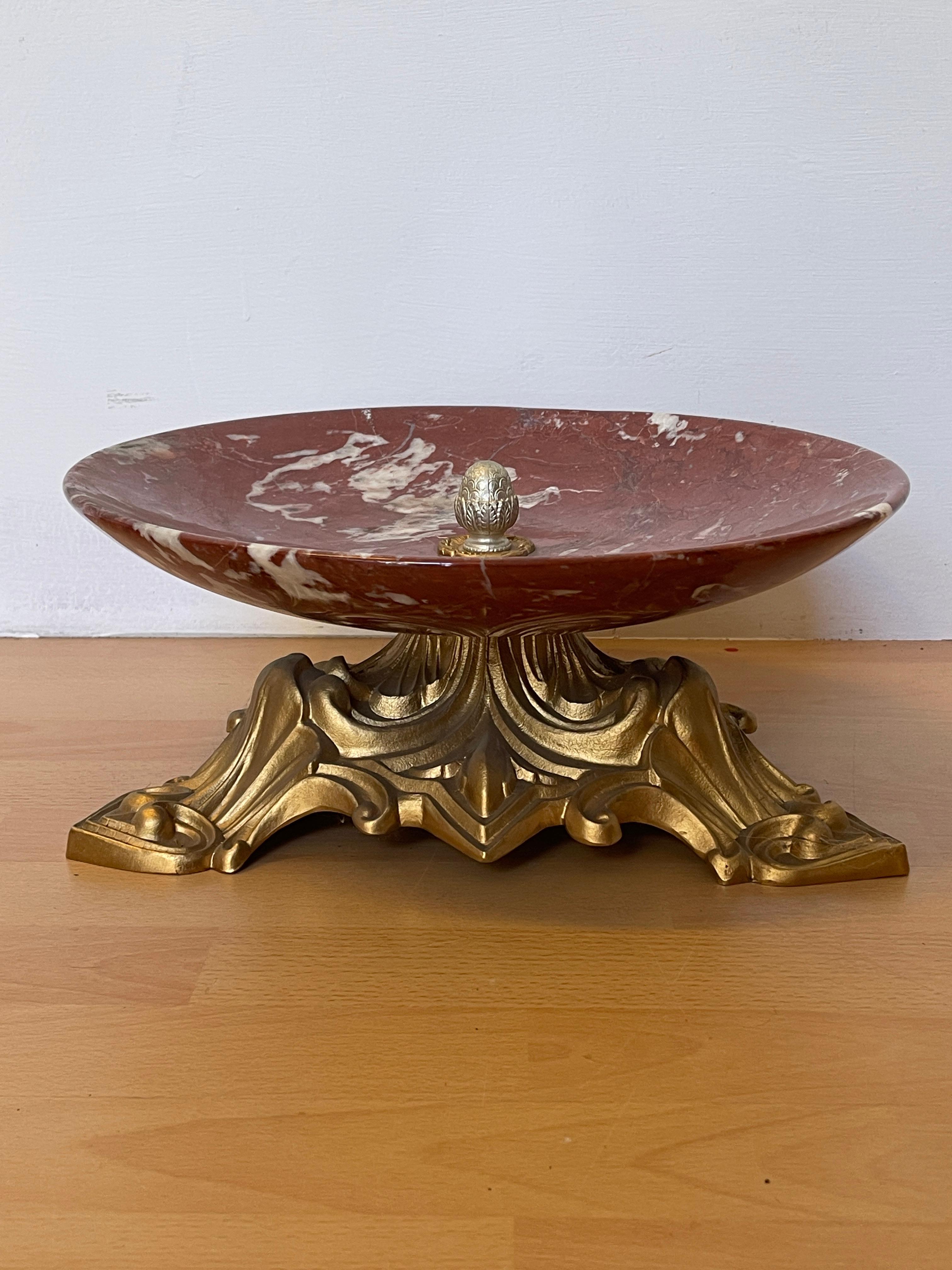 Prächtiger Mittelteller aus rot geädertem Marmor, auf einem eleganten und fein gearbeiteten Sockel aus vergoldeter Bronze. Der Teller mit seinem breiten, konkaven Design eignet sich perfekt für die Präsentation von Obst, Blumen oder