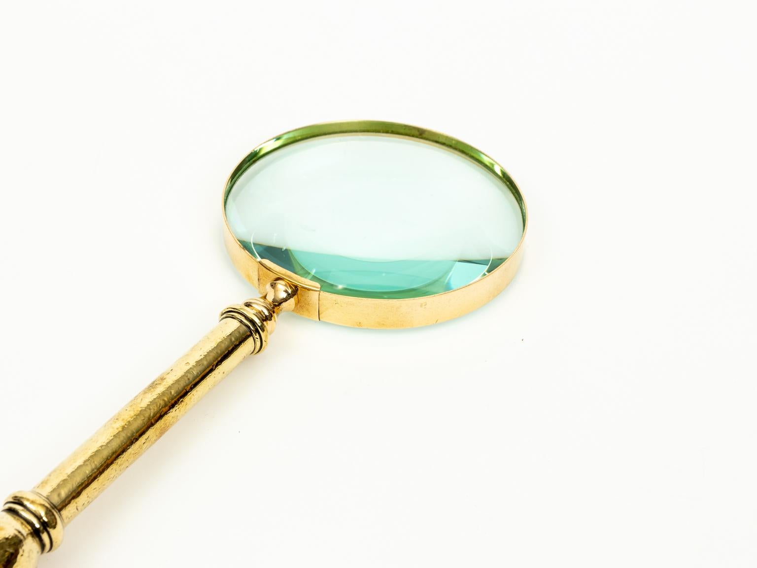 English brass magnifying glass in the Victorian style with urn shaped finial on the handle, circa 1890s. Made in England. Please note of wear consistent with age.