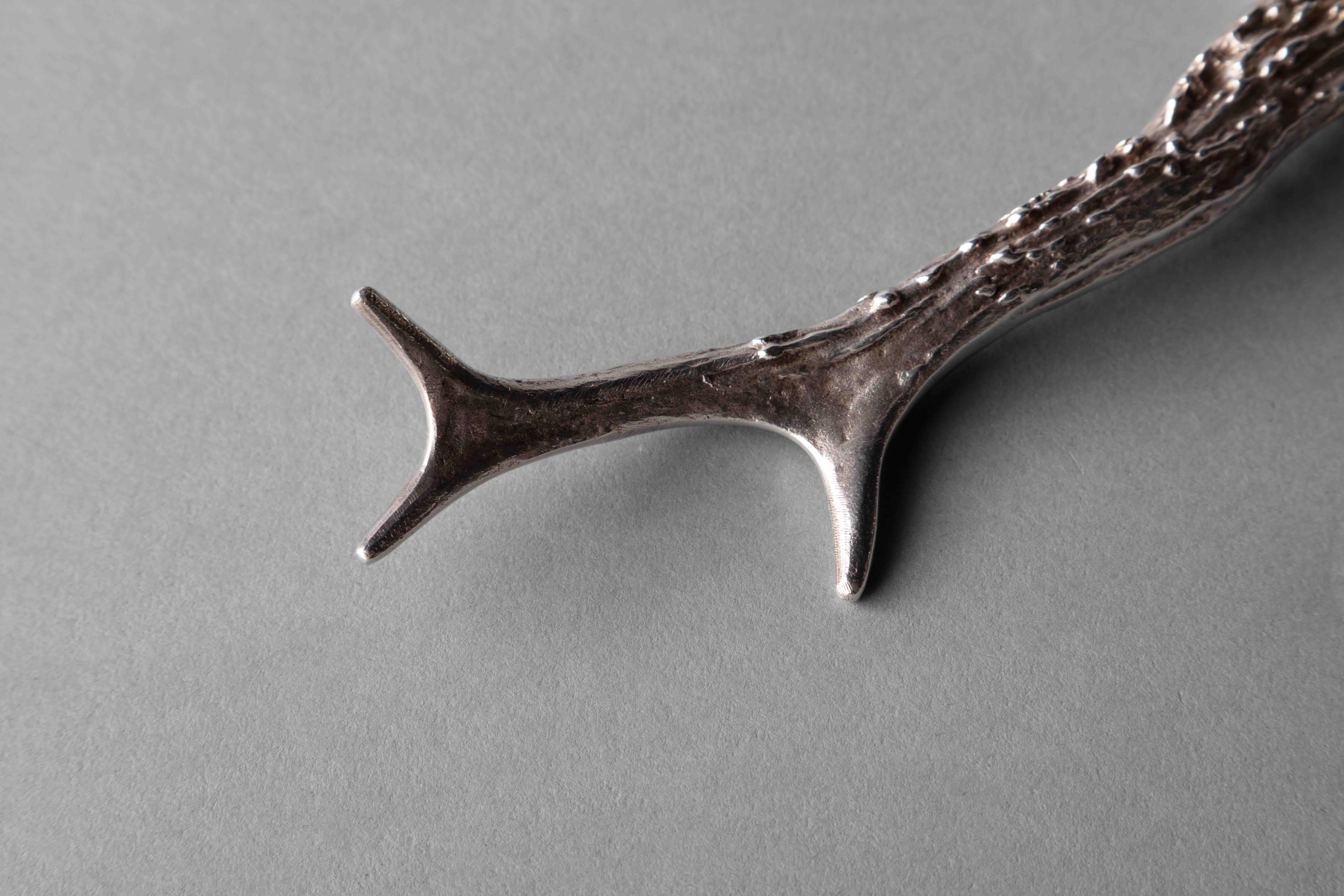Silvered magnifying glass with handle mimicking deer antlers.