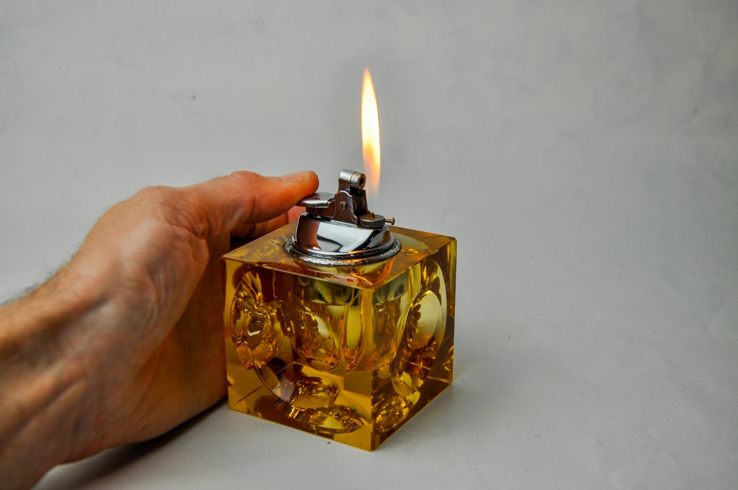 Superb and rare magnifying glass lighter designed and produced by Antonio Imperatore in Italy in the 1970s. Orange Murano glass lighter with a magnifying glass effect on its facets, handcrafted by Venetian master glassmakers. Decorative object that