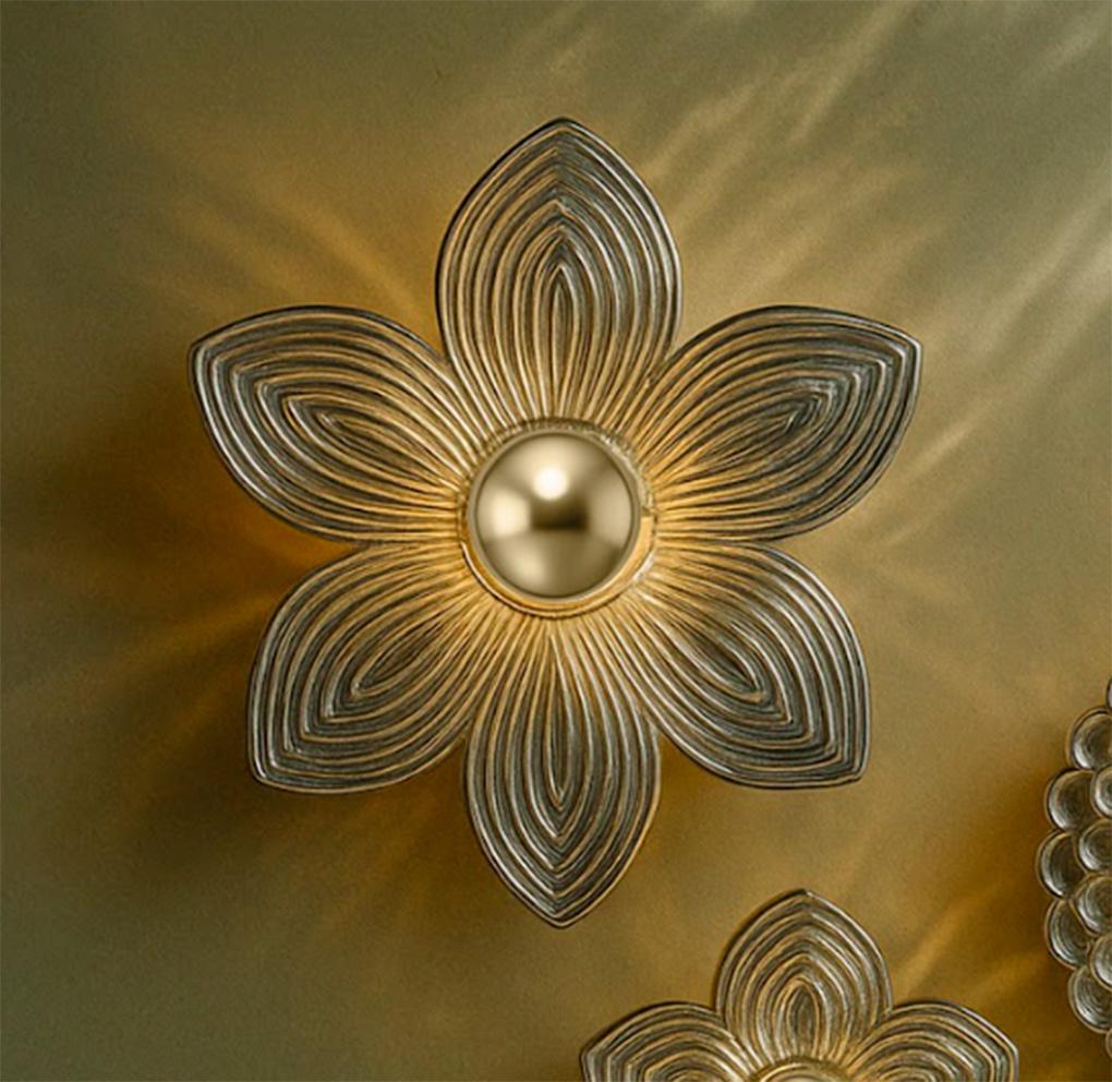 Xochipilli est une collection de luminaires muraux qui réimagine trois piliers floraux profondément ancrés dans la cosmologie mésoaméricaine - le magnolia, le dahlia et la fleur de cacao - comme des organismes lumineux flottant sur des murs minéraux