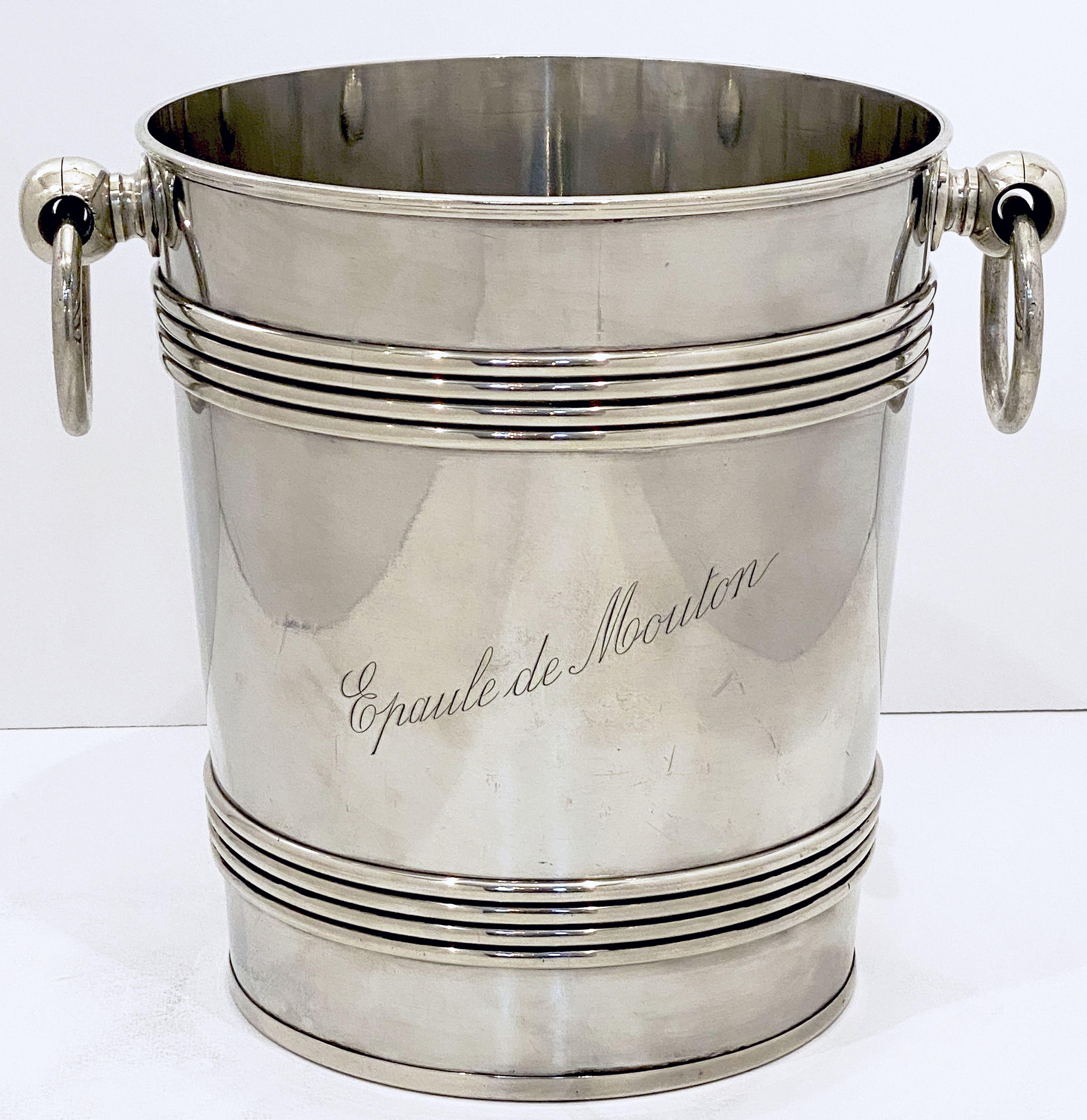 A fine extra large French ice bucket or champagne wine cooler of fine plate silver, featuring a rolled top edge, two opposing ring handles, banded rings around the top and base of the body - fitted for magnum-sized bottles of champagne and