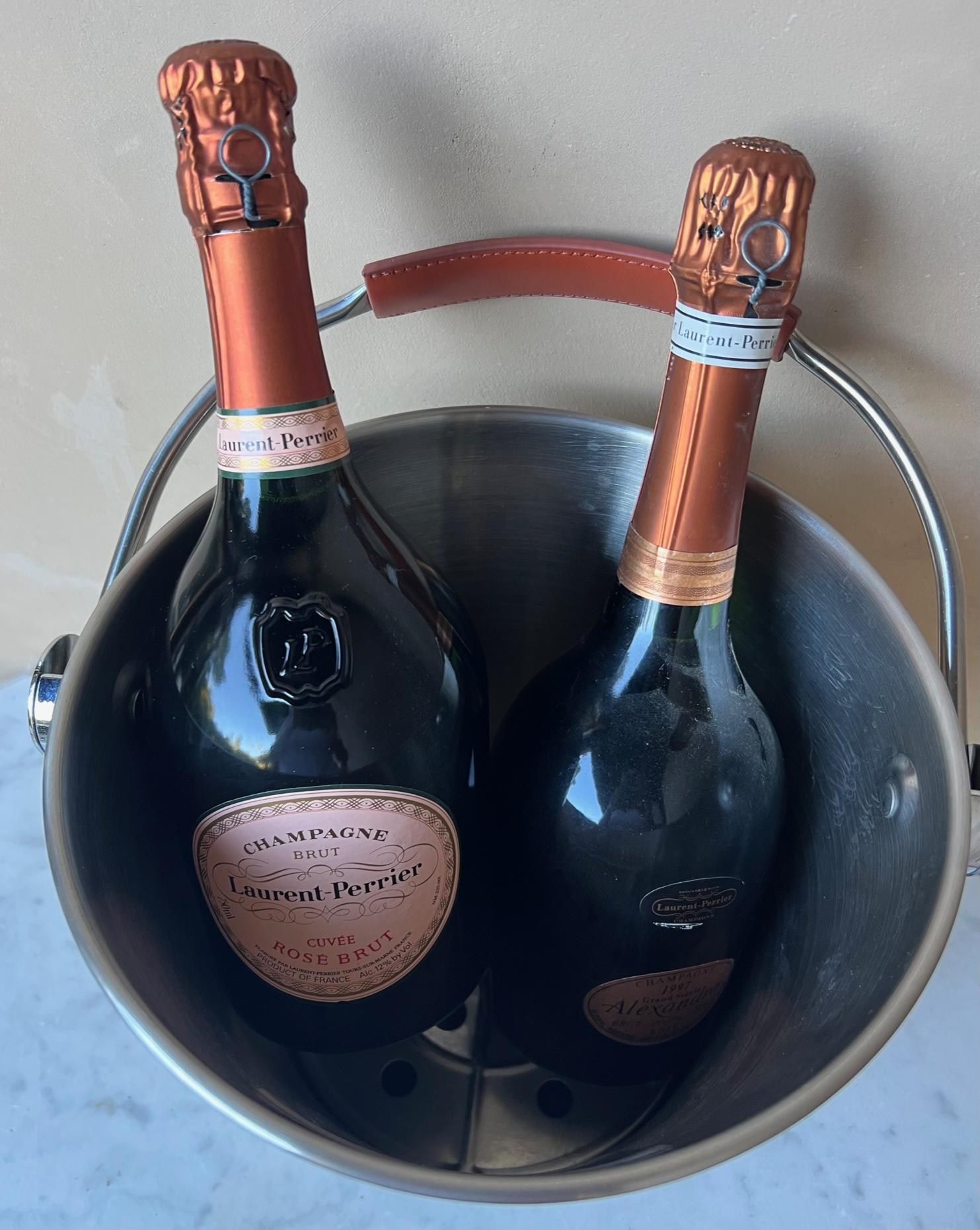 Large magnum or double champagne bottle sized metal bucket from Laurent-Perrier. The bucket includes a gold toned label, leather handle and removable strainer at the bottom.