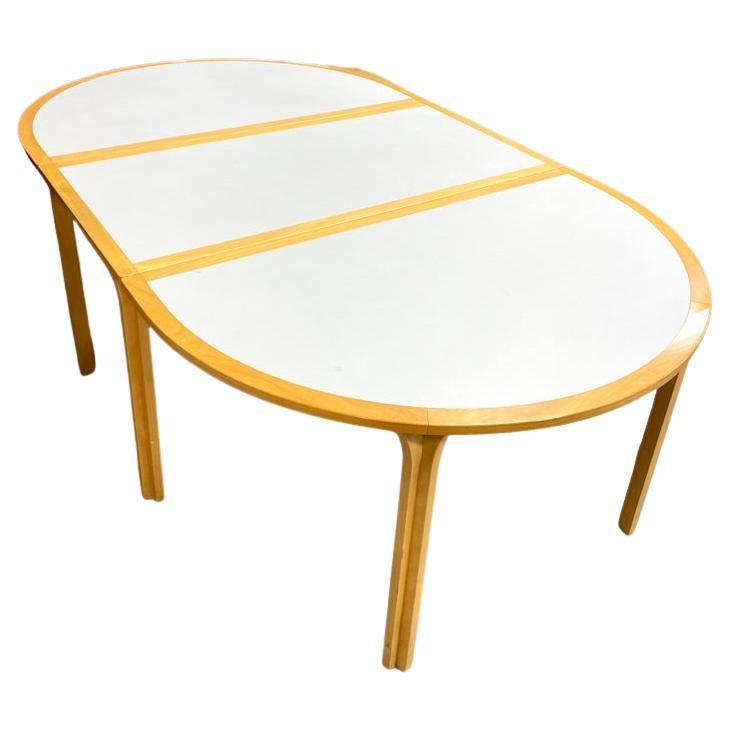 Mid Century Modern 1970s dining table designed by Rud Thygesen and Johnny Sorensen for Magnus Olesen. Made in Denmark. Includes 1 leaf. White top. 66.5-94in Long 55in Deep 28.5in Tall (Additional leaf adds 27.5 inches).