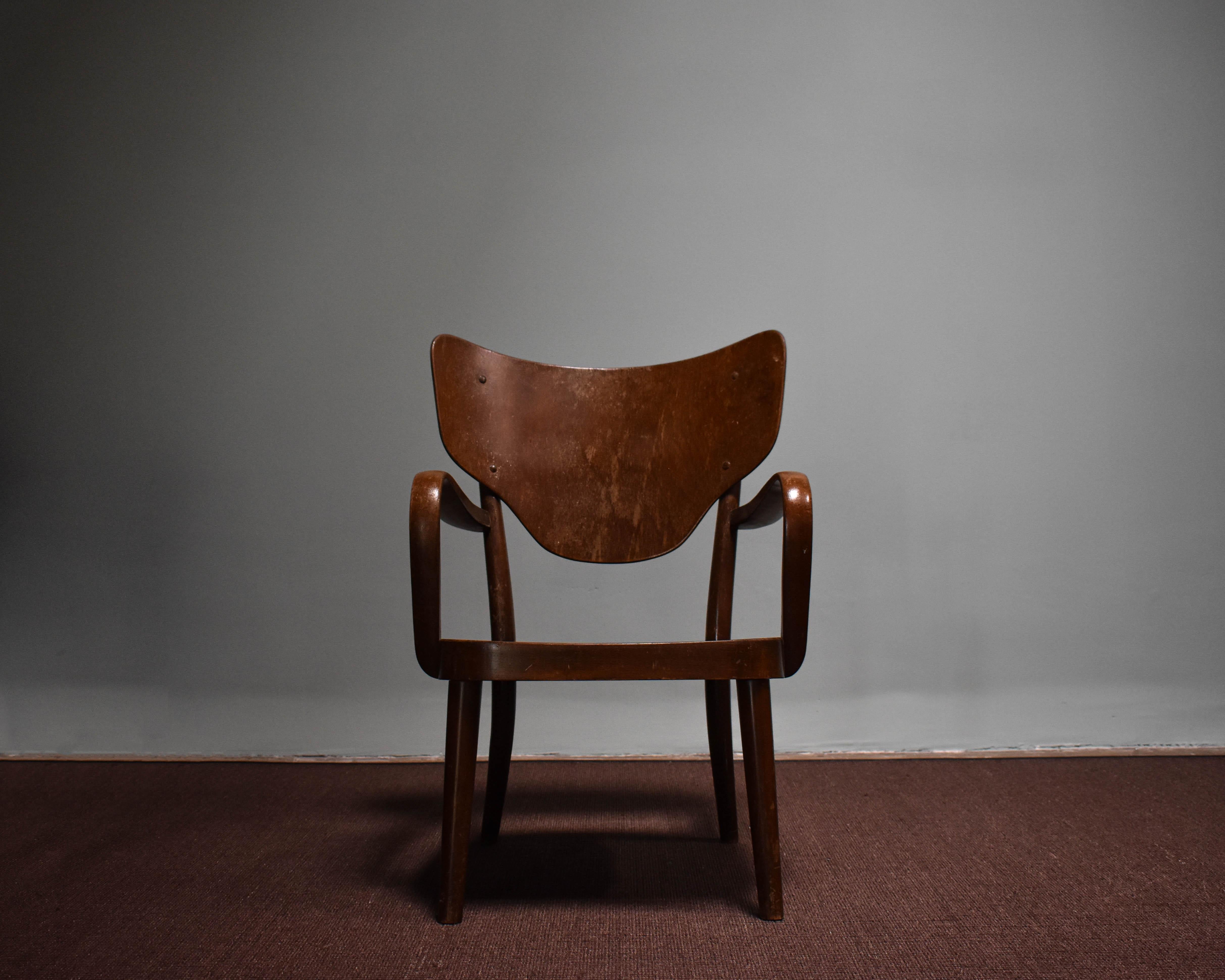 This lounge chair, designed by Magnus Stephensen in the 1940s, and crafted from stained beech.
Produced by the renowned Danish manufacturer Fritz Hansen, with characteristic of mid-century modern design. The underside of the chair is stamped with