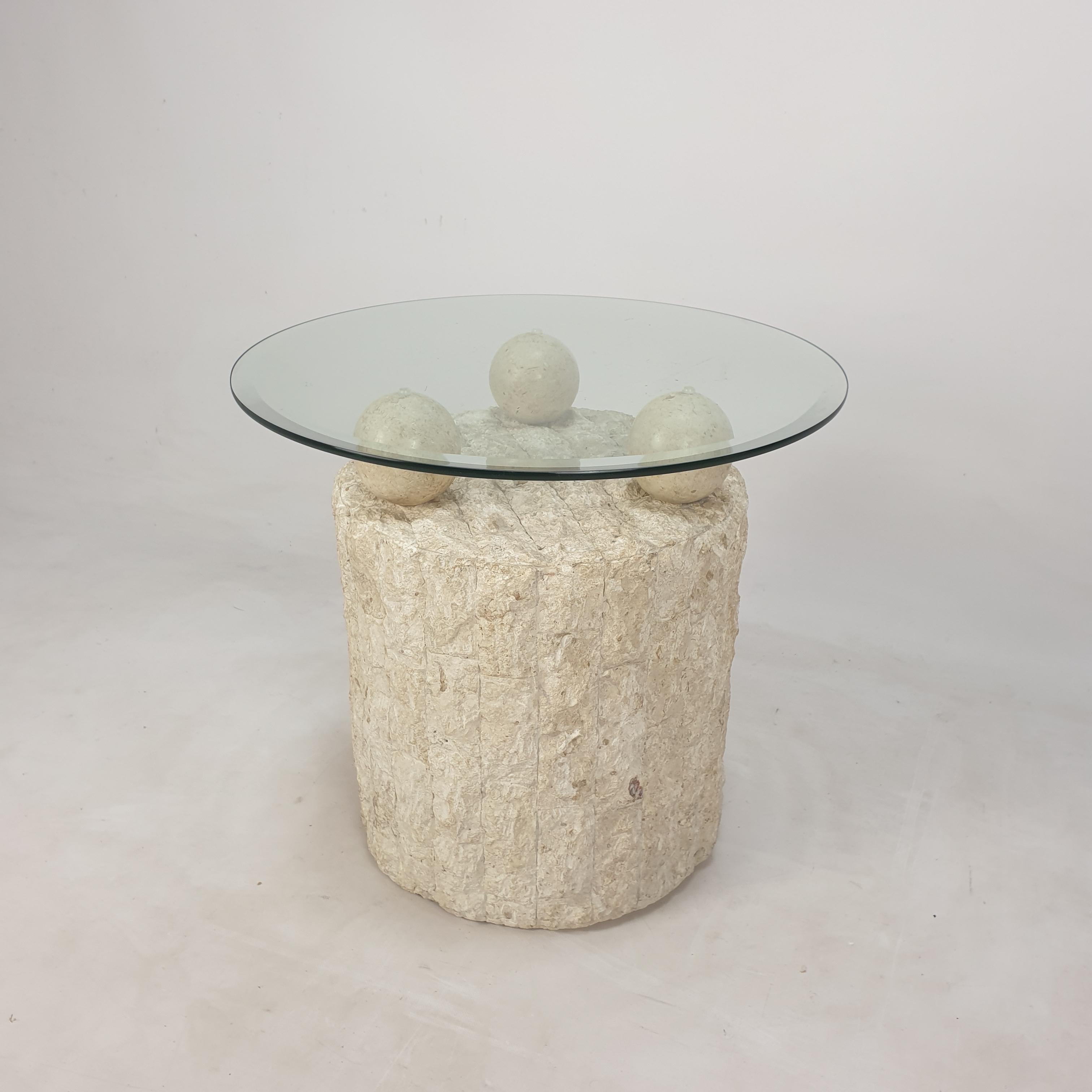 Lovely Postmodern 1980s design, coffee or side table by Magnussen Ponte.

The table base is made of rough edged brick motif Mactan stone or Fossil Stone. 

Three stone balls holding the removable circular glass top.