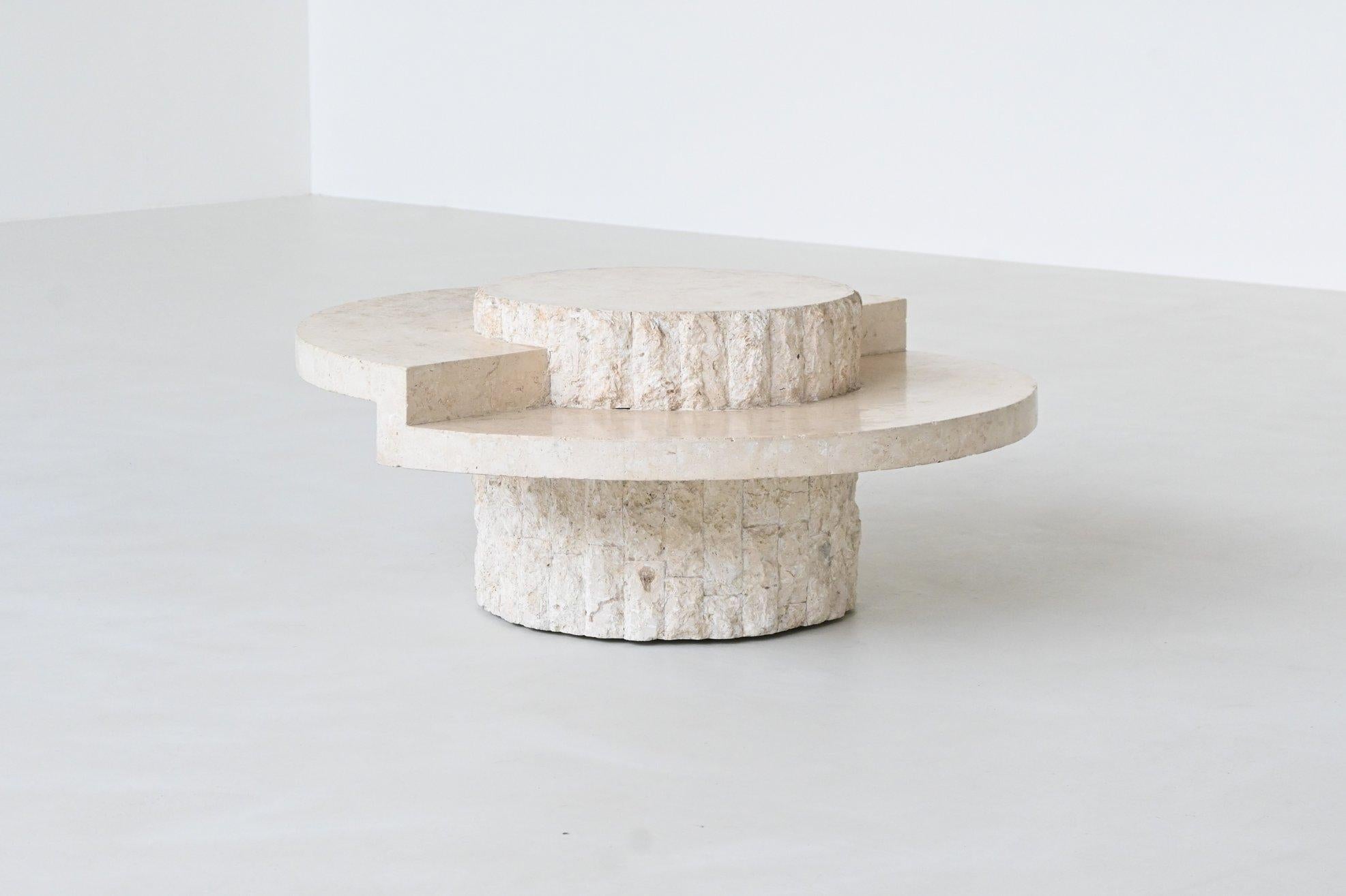 Beautiful sculptural round coffee table designed and manufactured by Magnussen Ponte, Belgium 1970. The top is made of highly polished cream white Mactan stone supported by a signature textured carved stone tile base. This table offers an artful