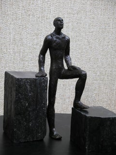 Le veilleur, figurative bronze by Maguy Banq, men standing within slate rocks