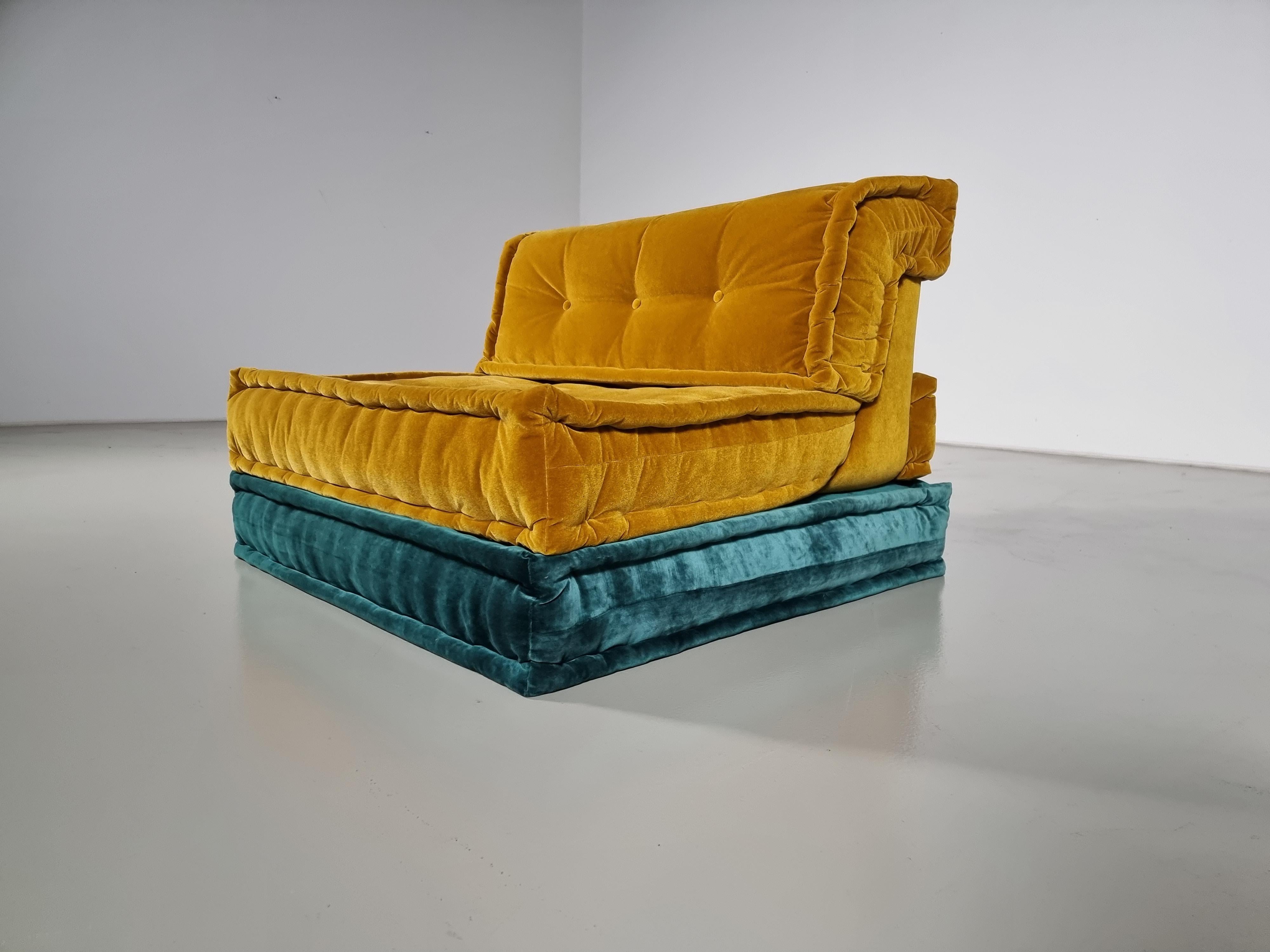 Chaise longue Mah Jong en velours jaune et bleu de Hans Hopfer, conçue en 1971 pour Roche Bobois.  

Le Mah Jong de Hopfer est l'un des sièges les plus emblématiques du milieu du siècle dernier. Le textile luxueux et saisissant de Missoni lui