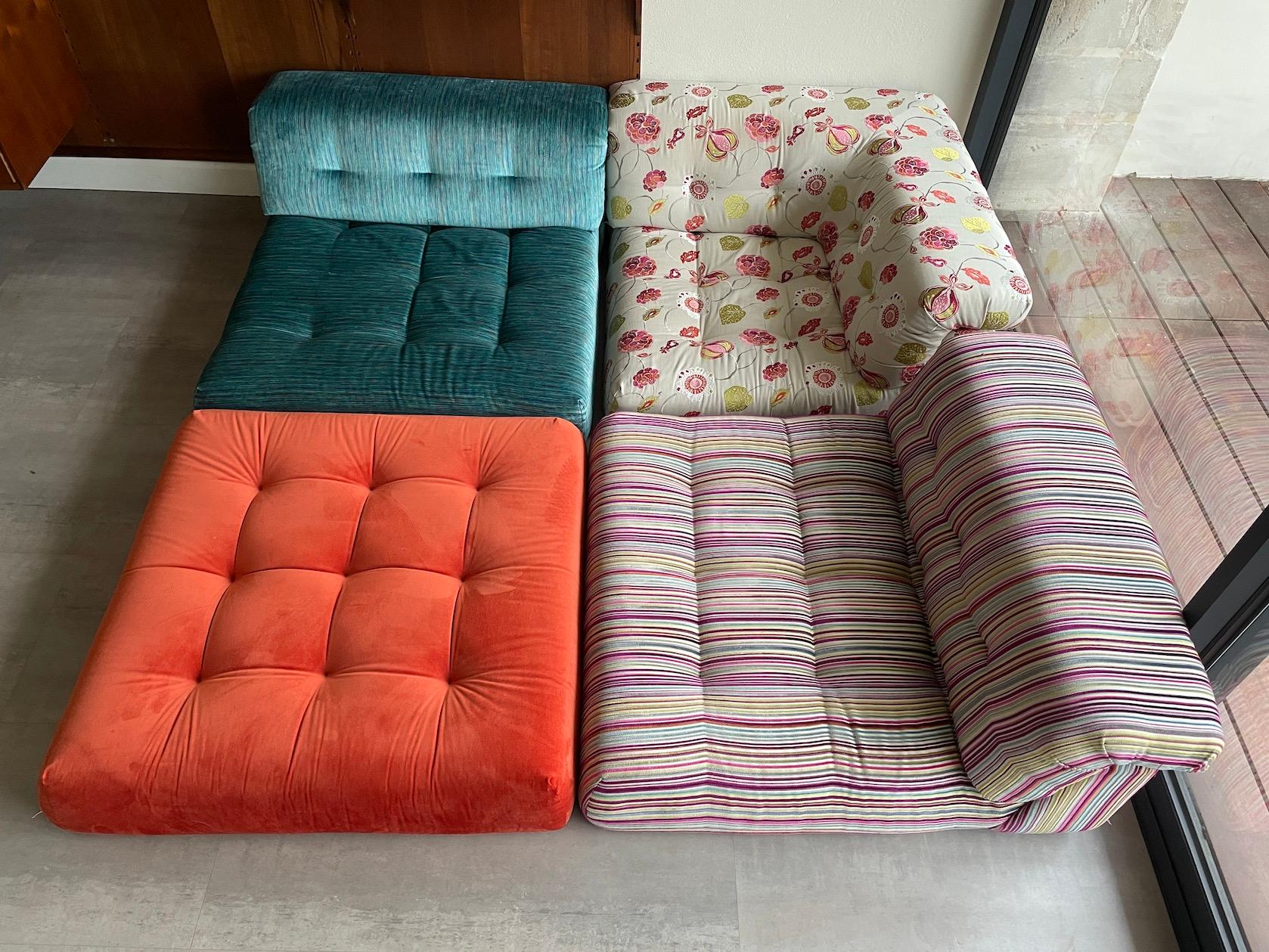 Mah Jong set composable by elements, dressed in blue, orange, floral and multicolored stripes fabrics. Fully modular system, it can be composed from four seat cushions at ground level: a corner cushion with backrest, two cushions with straight