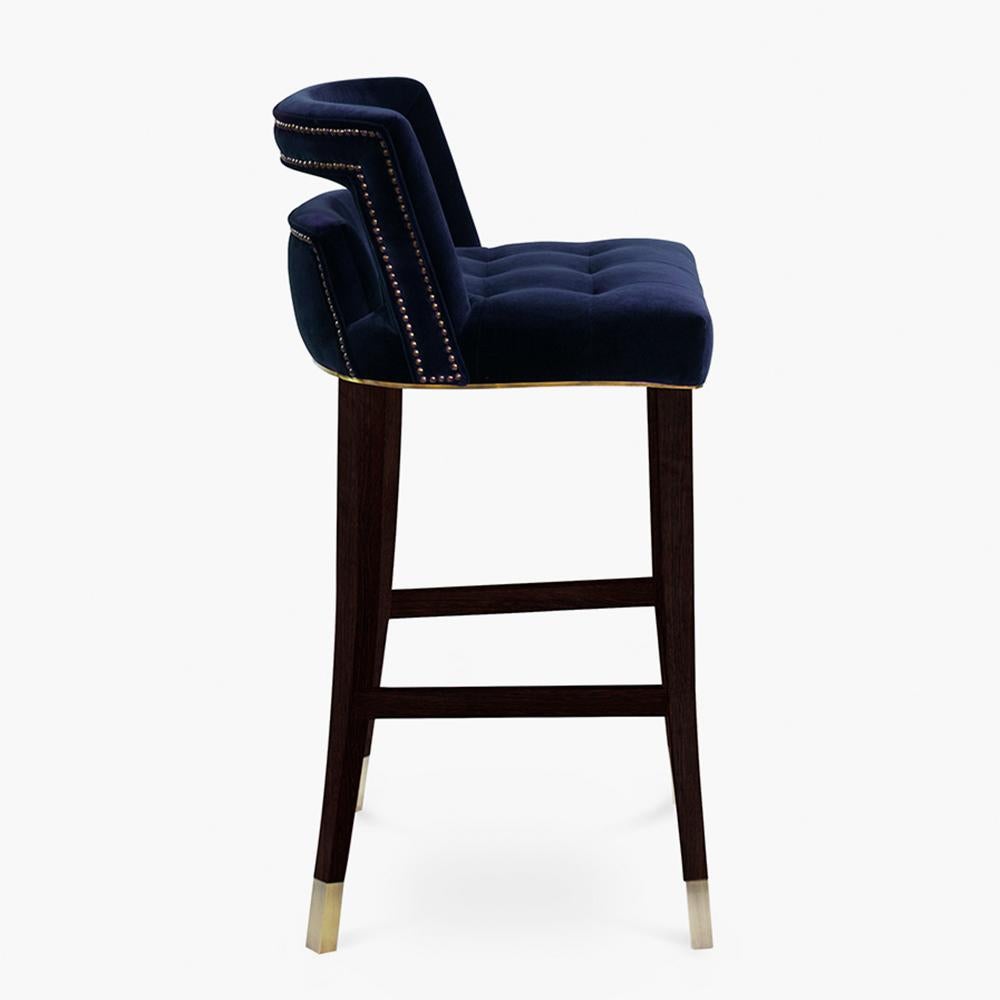 Taburete de bar Mahal con estructura de madera maciza de fresno, asiento
totalmente tapizada y recubierta de tela velevt azul.
Patas en acabado de chapa de nogal mate con latón macizo
Pies de los extremos y embellecedor bajo el asiento en acabado