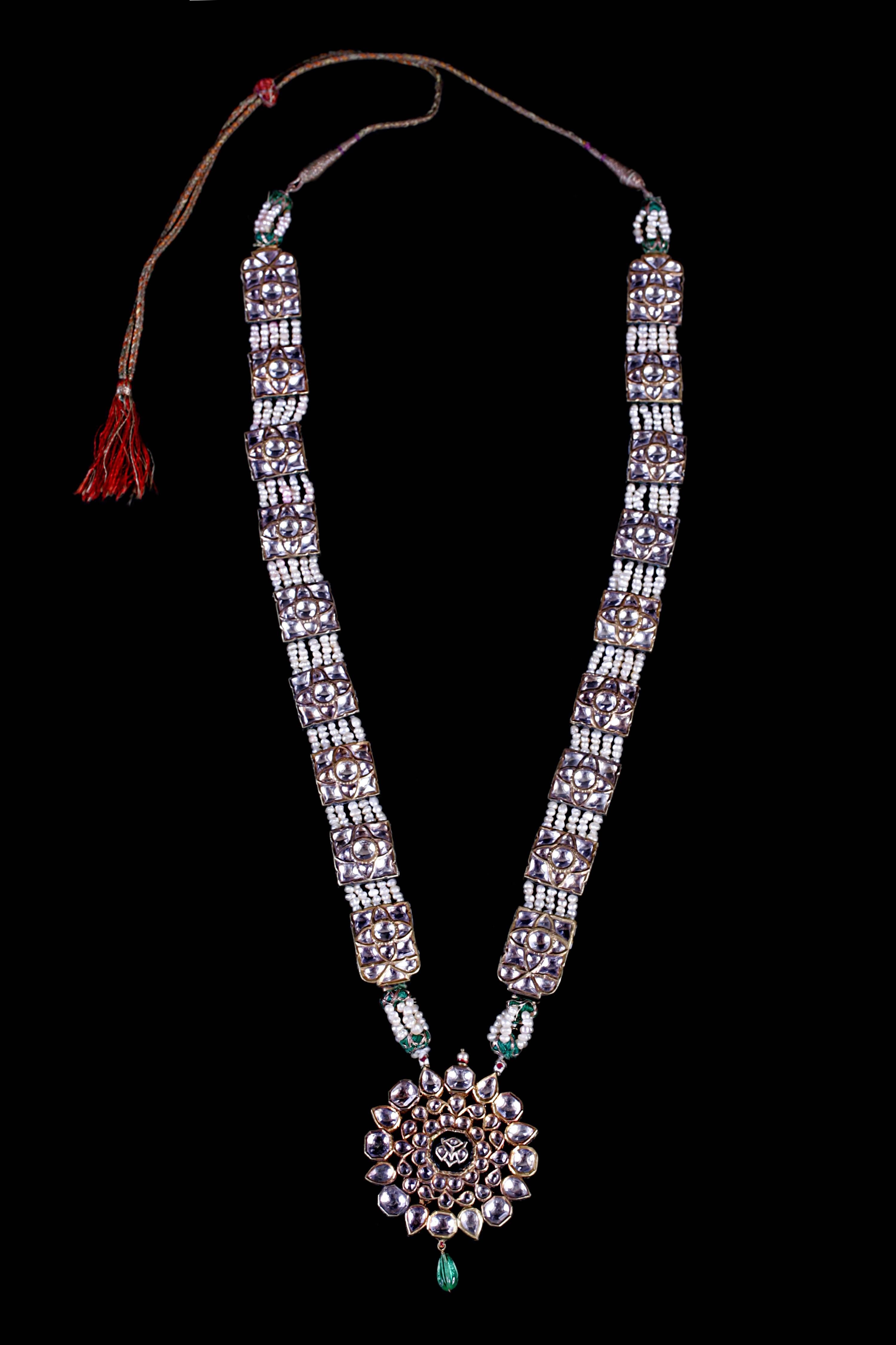 Important Prince (Maharaja to be) necklace with a gold flower shaped medallion with white sapphires, enamel on the back and gadroon emerald cabochon suspended by an impressive chain of gold squares inlaid with white sapphires and beautiful enamel