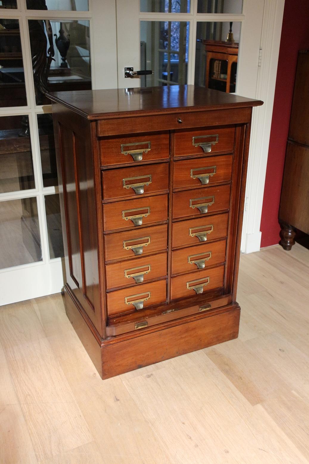 Antique mahogany filing cabinet from the famous company Shannon from the US. They also had a European branch in London. This one was made for the European market
This is a filing cabinet with 12 drawers and lockable by a roller shutter. The filing