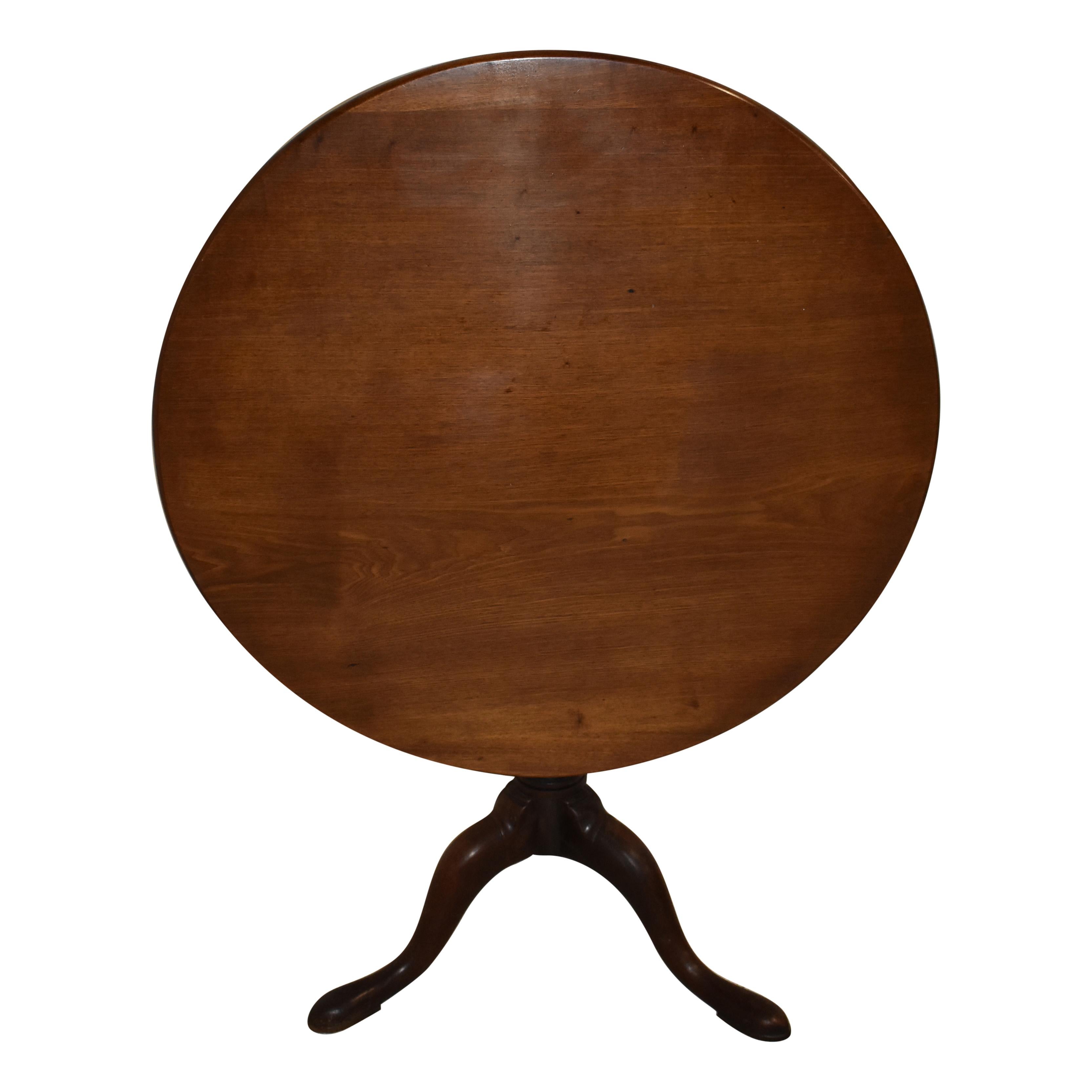 This Classic tilt-top table features a round top over a birdcage mechanism that allows the table's top to be tilted up when not in use. The top is supported by a turned pedestal with tripod cabriole legs that dovetail into the pedestal, which is