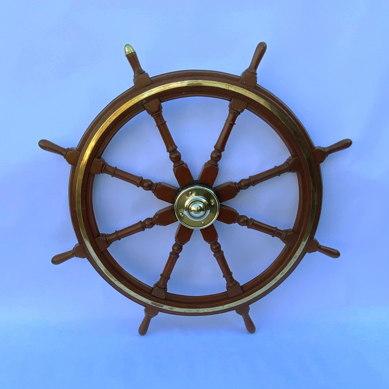 Antique eight spoke ship's wheel with brass hub and trim ring. Varnished wood finish and highly polished brasses. This is burly, strong ship's wheel from the late nineteenth century. Circa 1890. Made in England.