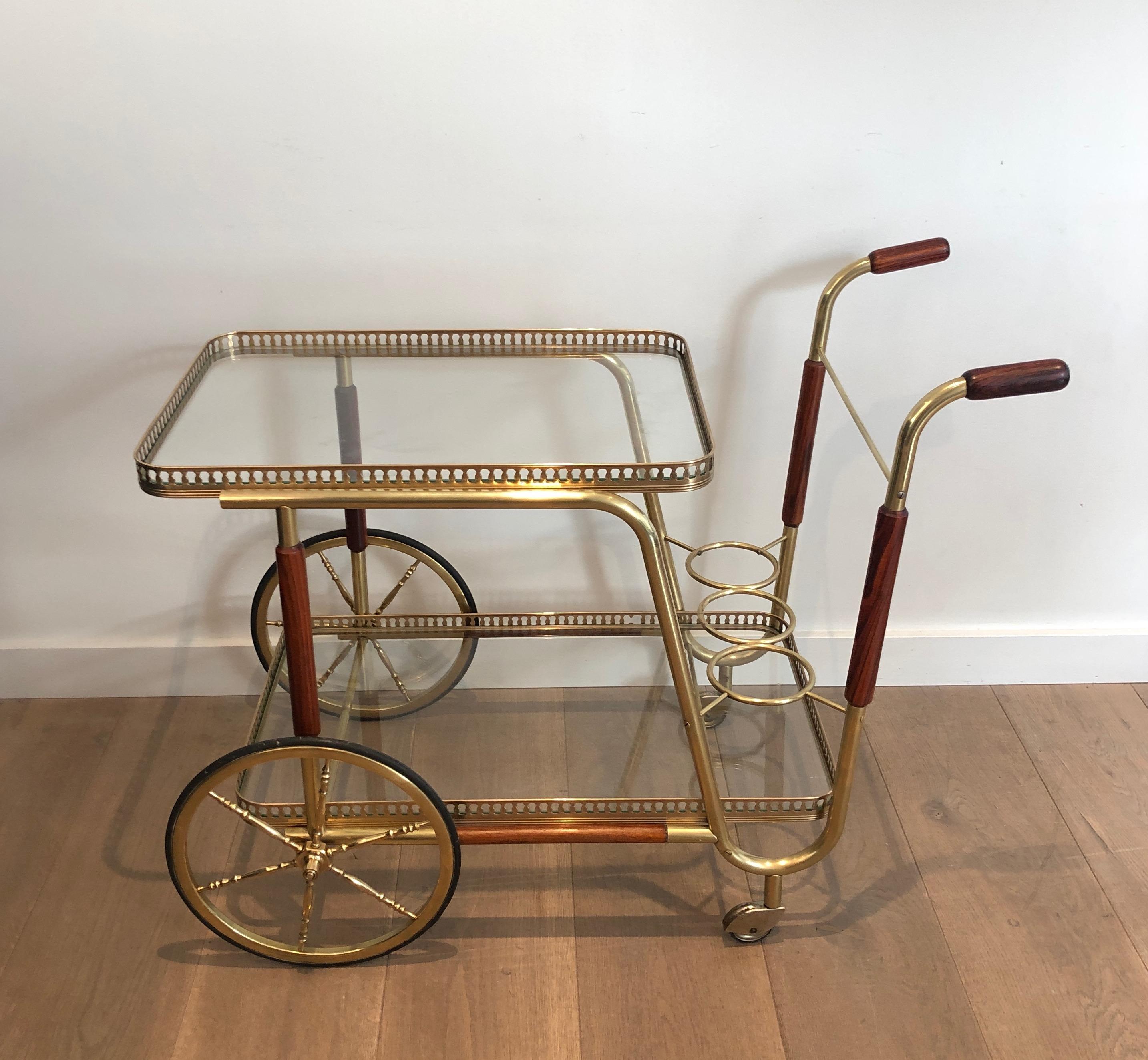 This neoclassical style drinks trolley is made of mahogany and brass. This is a French work, circa 1940.