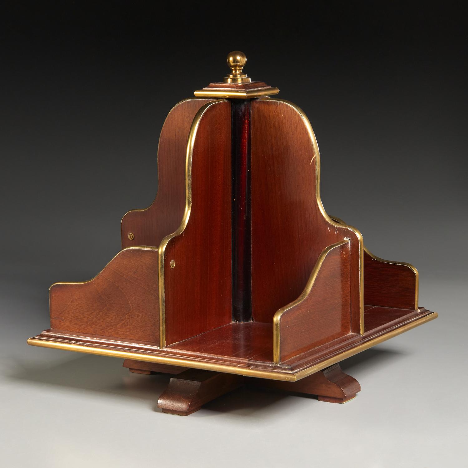 19th c., England, mahogany brass mounted rotating stand divided into four compartments, topped with a brass finial. A handsome addition to any desk, providing an interesting talking point and a fine way to store your upcoming reads. An opportunity
