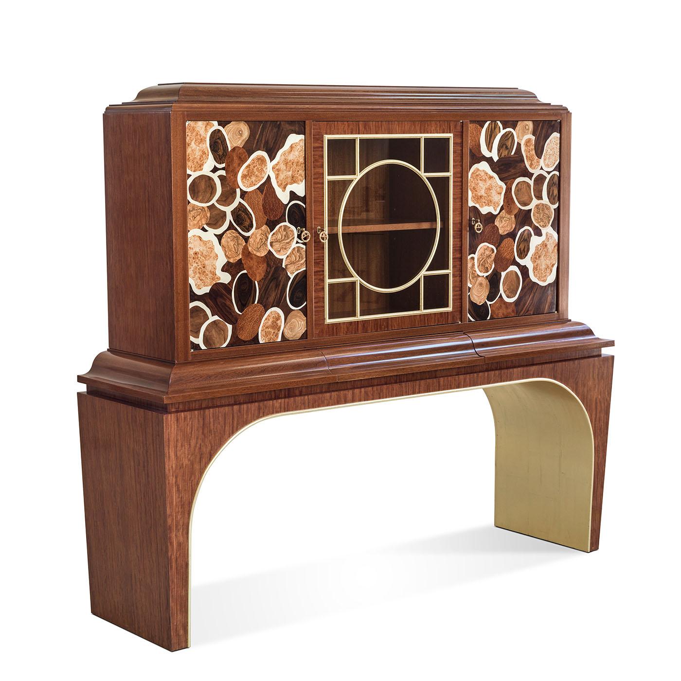 This precious cabinet is expertly crafted from Mahogany and Bubinga wood and it featured intricately inlaid doors and elegant brass details.