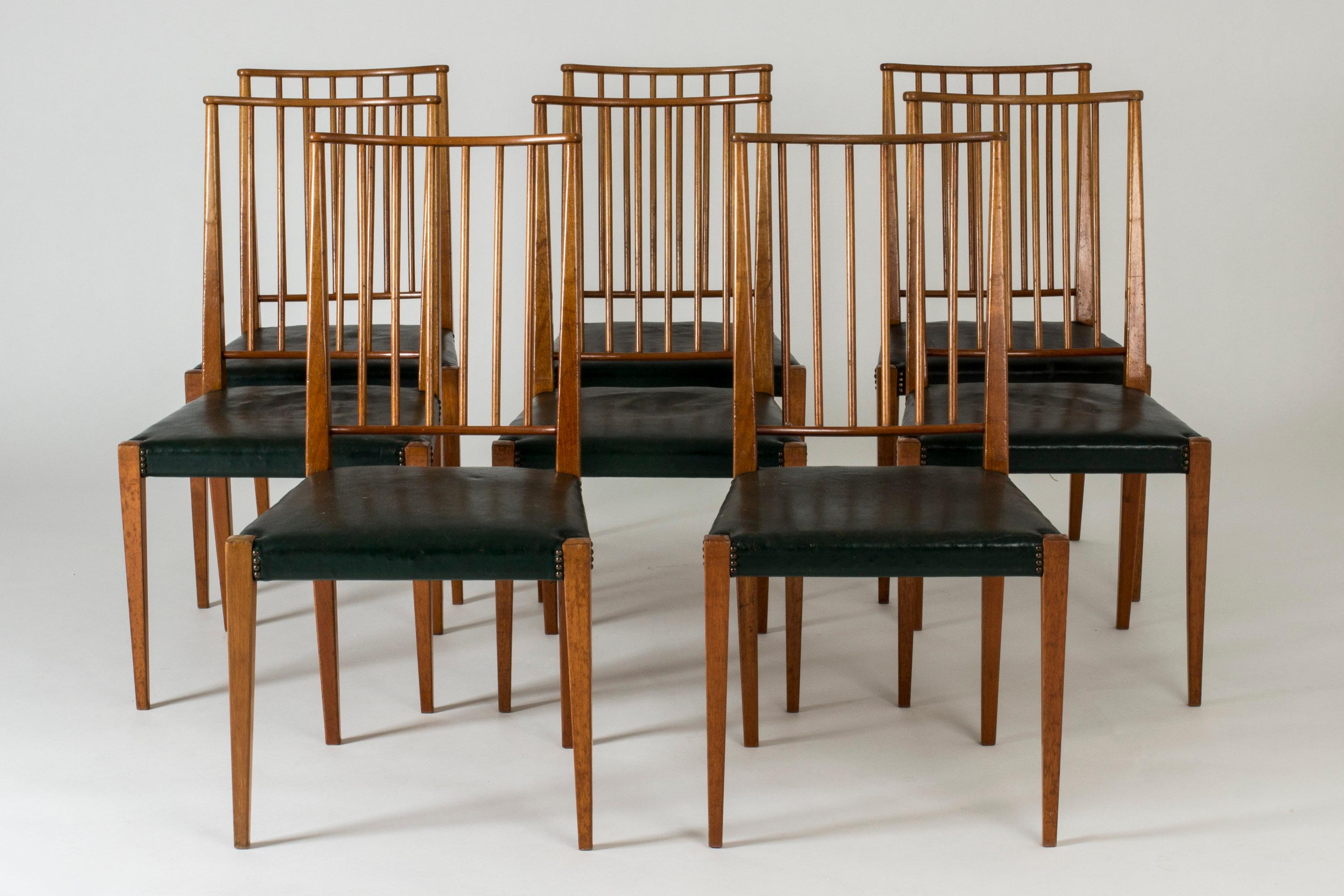 Set of eight dining chairs by Josef Frank, made from mahogany with green leather seats. Elegant slender lines with tall, ribbed backs. Decor of brass nails around the corners of the seats.
Original green leather seats, some with patina and small