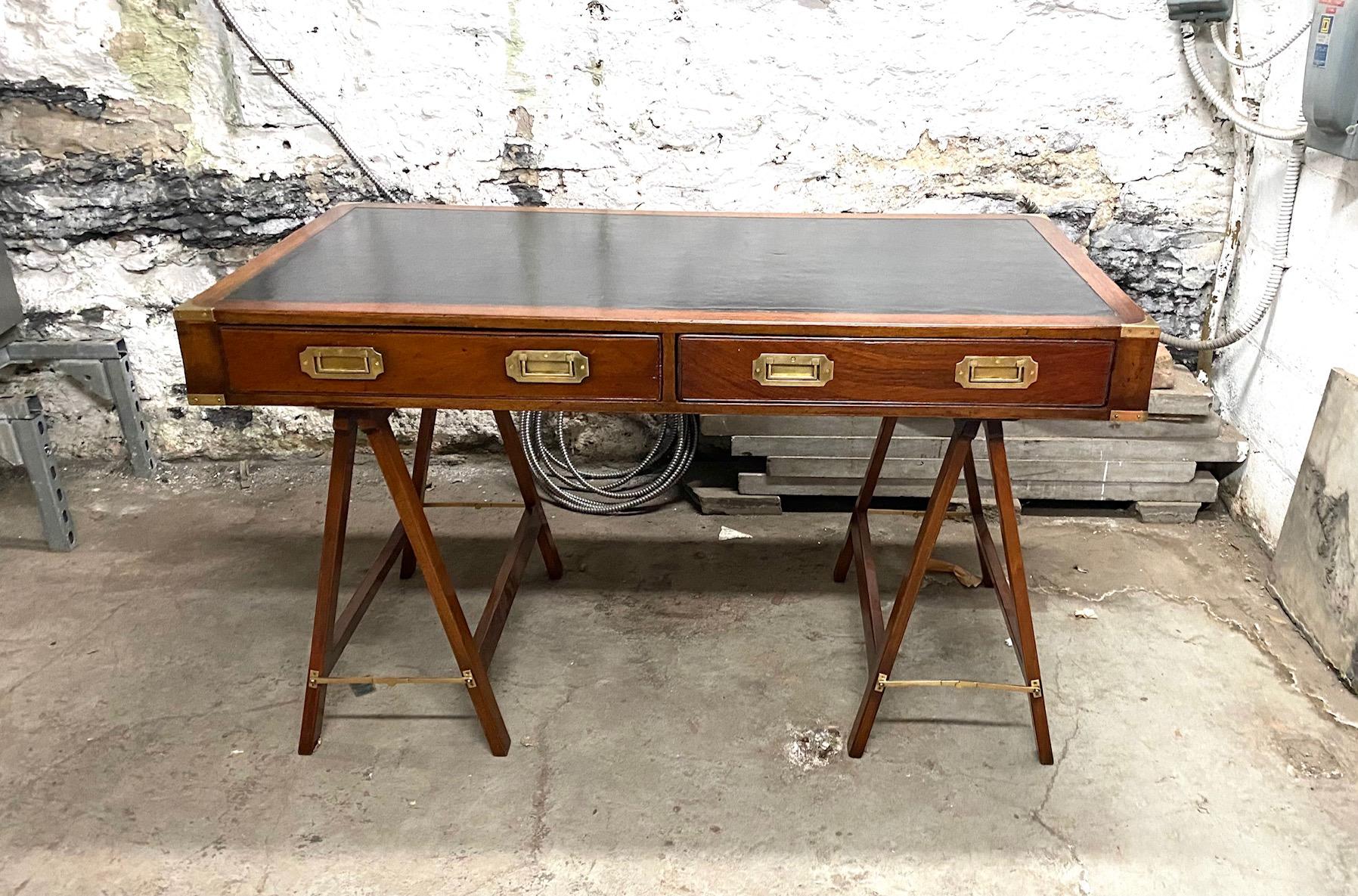 English Campaign Desk resting on stretcher and inset with black leather top and decorated with brass handles