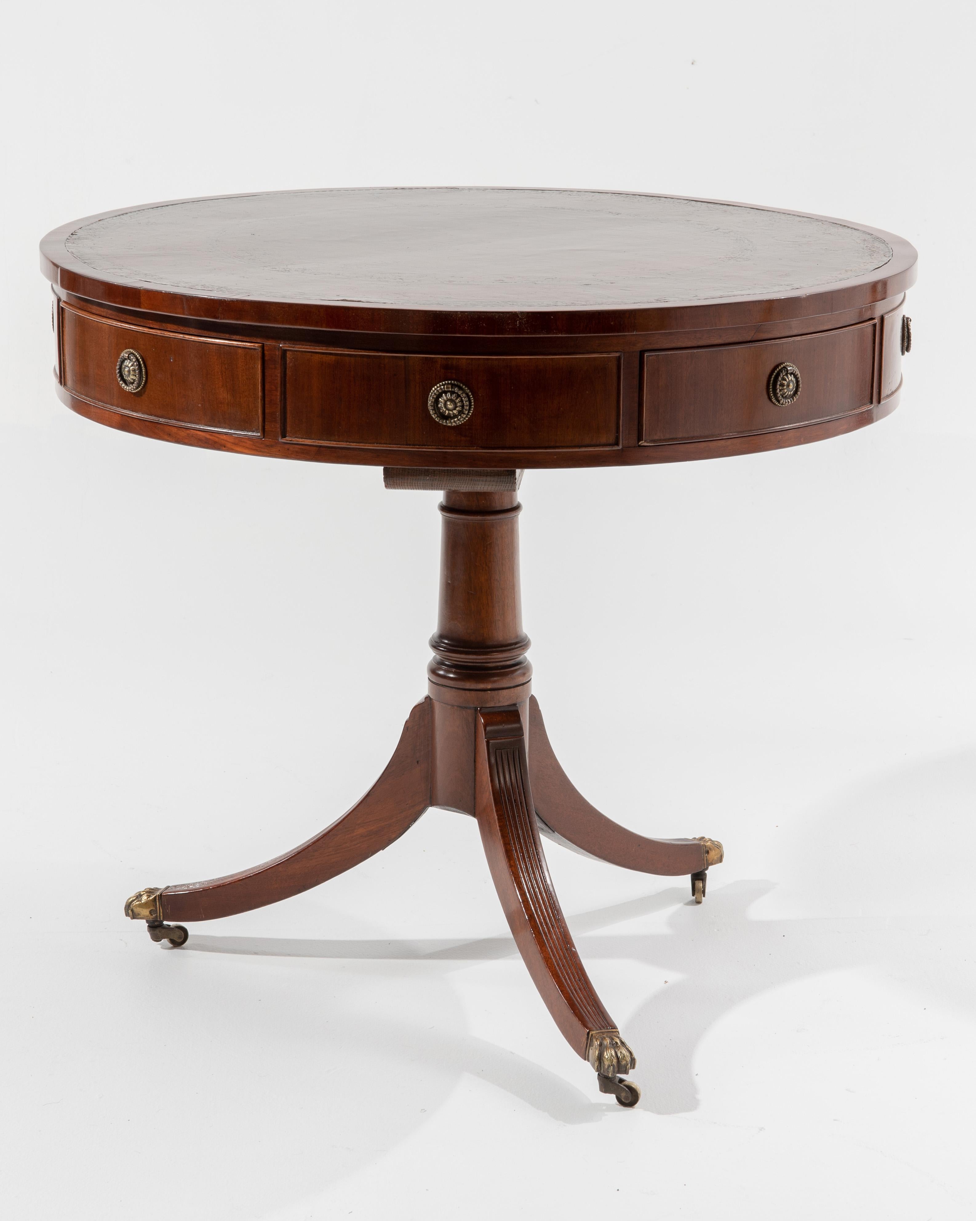 Graceful and Classic cabinetmaker rent table. The leather top with gilt tooling decoration with brass ring handles on the surrounding drawers resting on a Classic splayed pedestal base with brass castors, early 20th century, circa 1910 from a New