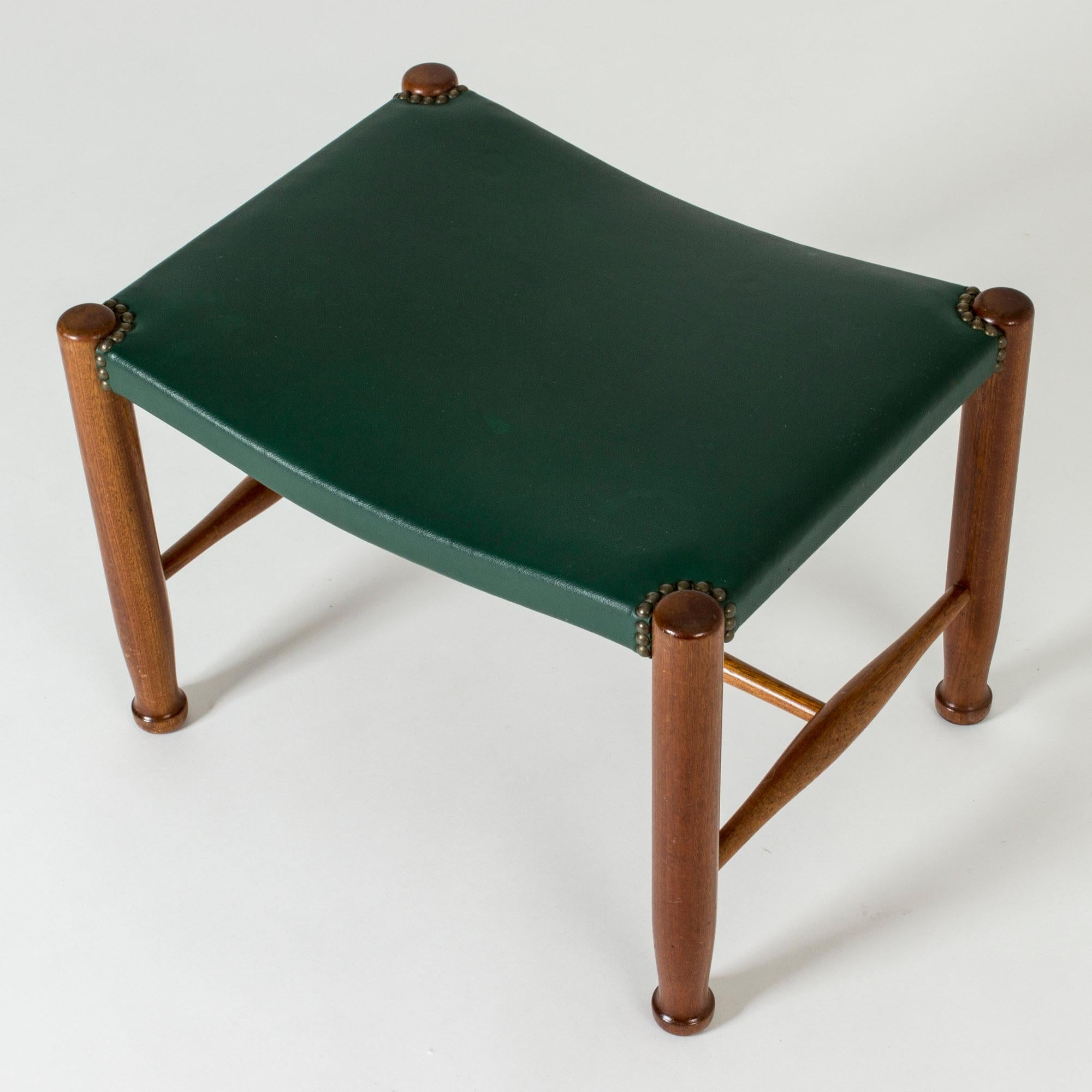 Neat stool by Josef Frank, made from mahogany with sculpted legs. Original green leather seat, with decorative nails around the joinery of the legs.