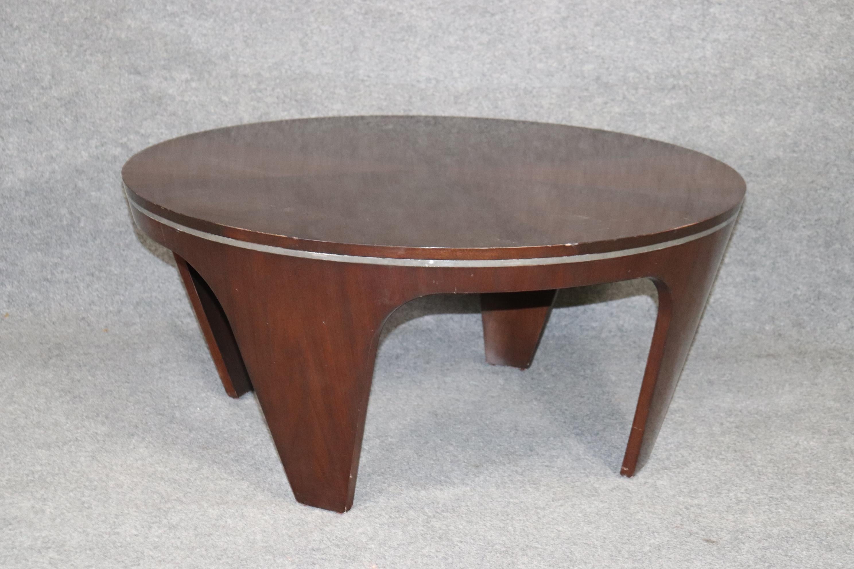 This is a unique art deco inspried coffee table in the style of Pierre Cardin. The table is figured mahogany with a band of some form of metal that surrounds it. The table will be cleaned and polished to make it look its best. The table measures 42