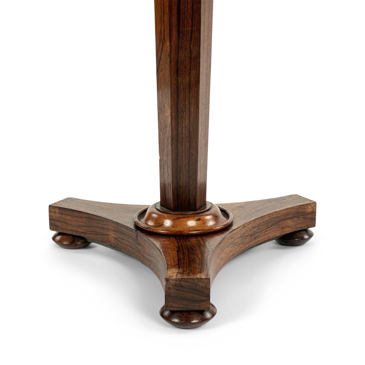 Mahogany and rosewood octagonal-top pedestal table: mahogany octagonal top with raised gallery edge upon rosewood pedestal base supported by three bun feet. Circa 1810-1830, England.