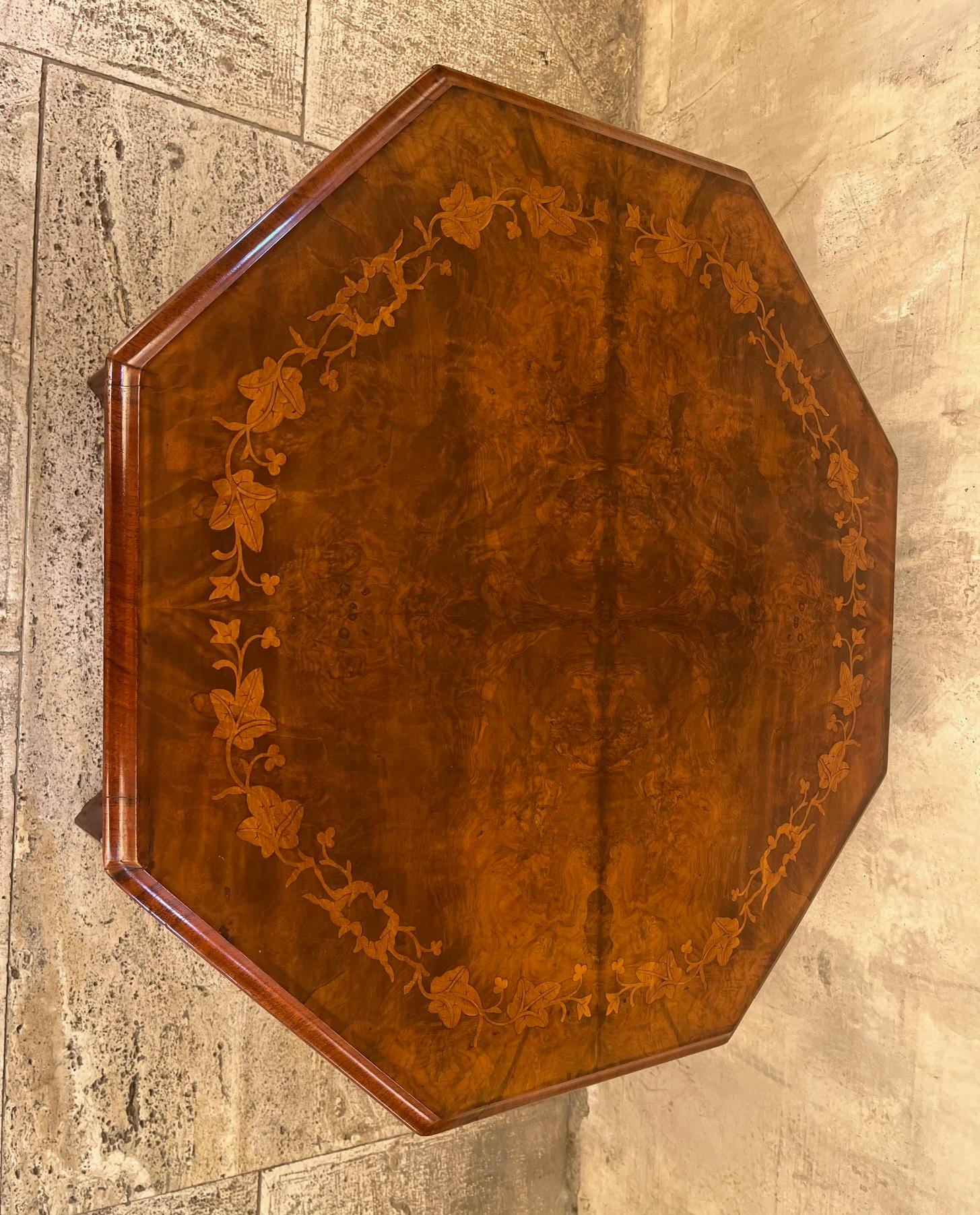 Mahogany wood coffee table with walnut burl wood top inlaid with maple wood floral motif at the bottom a threaded mahogany shelf and on the 2 sides an openwork railing Charles X period.