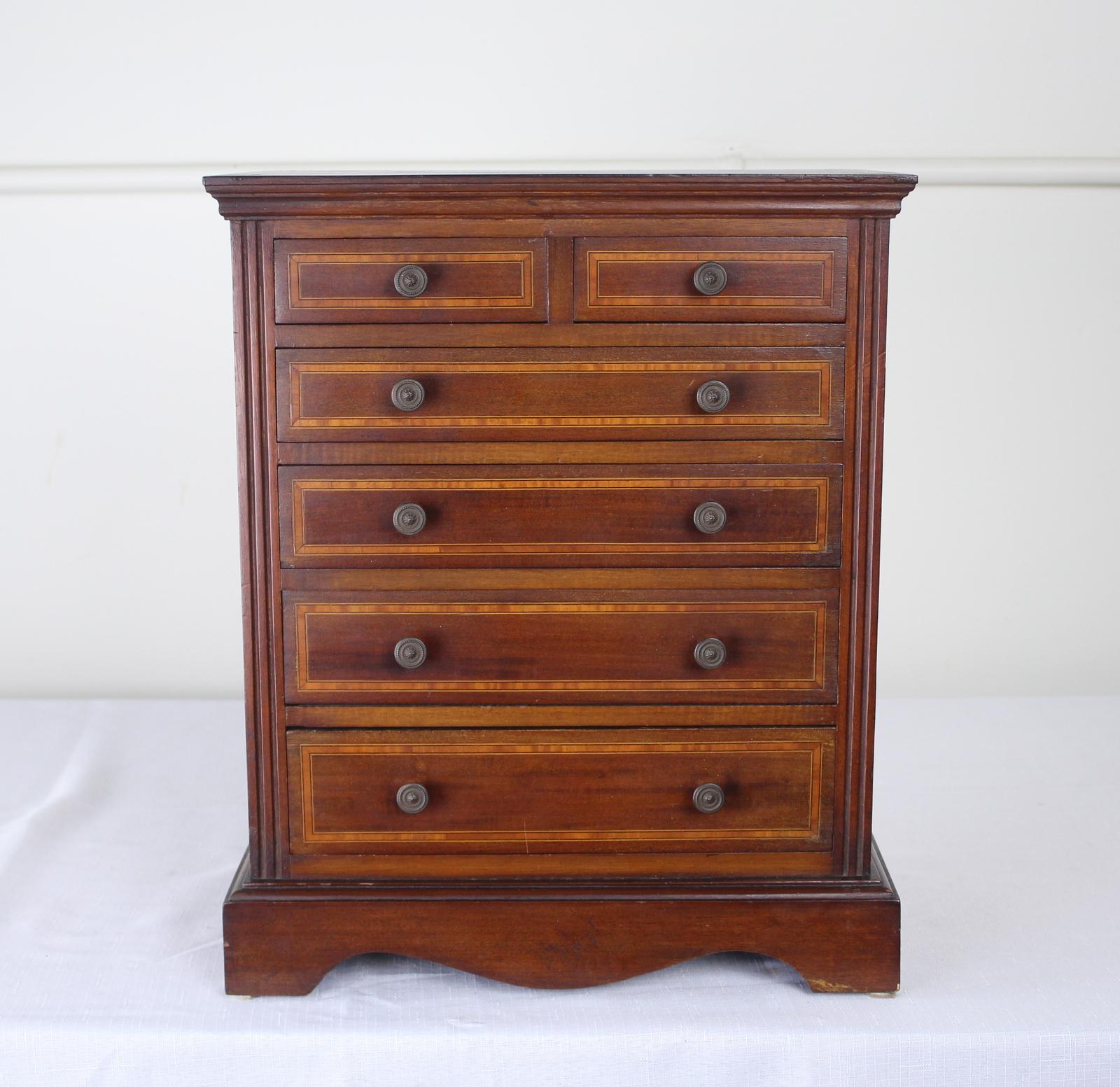 A beautifully made mahogany apprentices' practice chest of drawers with satinwood inlay. Handsome mouldings at top and and carved plinth at the bottom. Lovely antique patina. Great for jewelry or as a decorative conversation starter. Interiors of