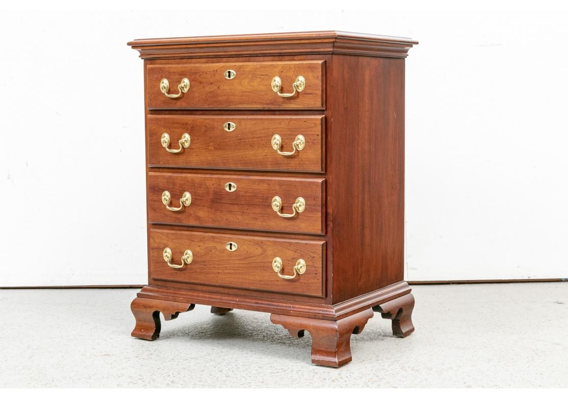 A classic small scale mahogany bachelor's chest with four drawers with brass bales and faux key holes. Raised on fine wide bracket feet. Variety of uses including as a night stand. The finish includes intentional distressing. 

W. 23, Depth 16 1/2