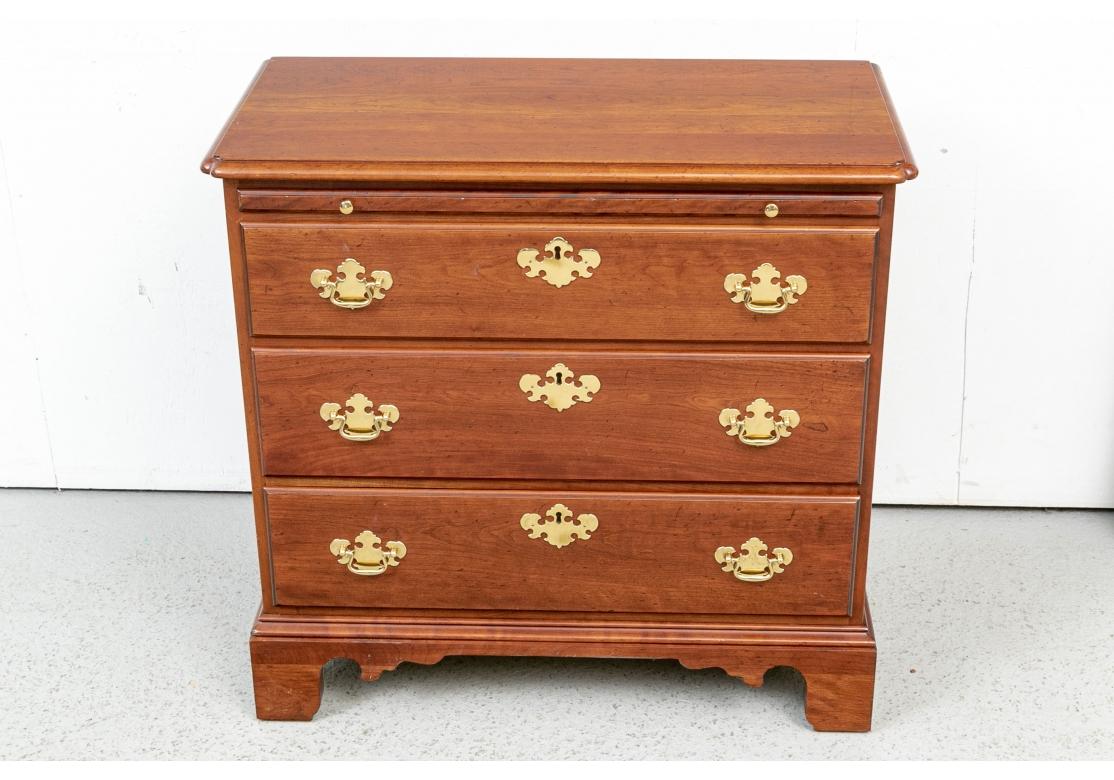 A handsome and very well made  chest with a slide pull over three long drawers with fine brass bat wing bales and faux escutcheons. Raised on wide bracket feet. Intentional distressing. 
W. 32