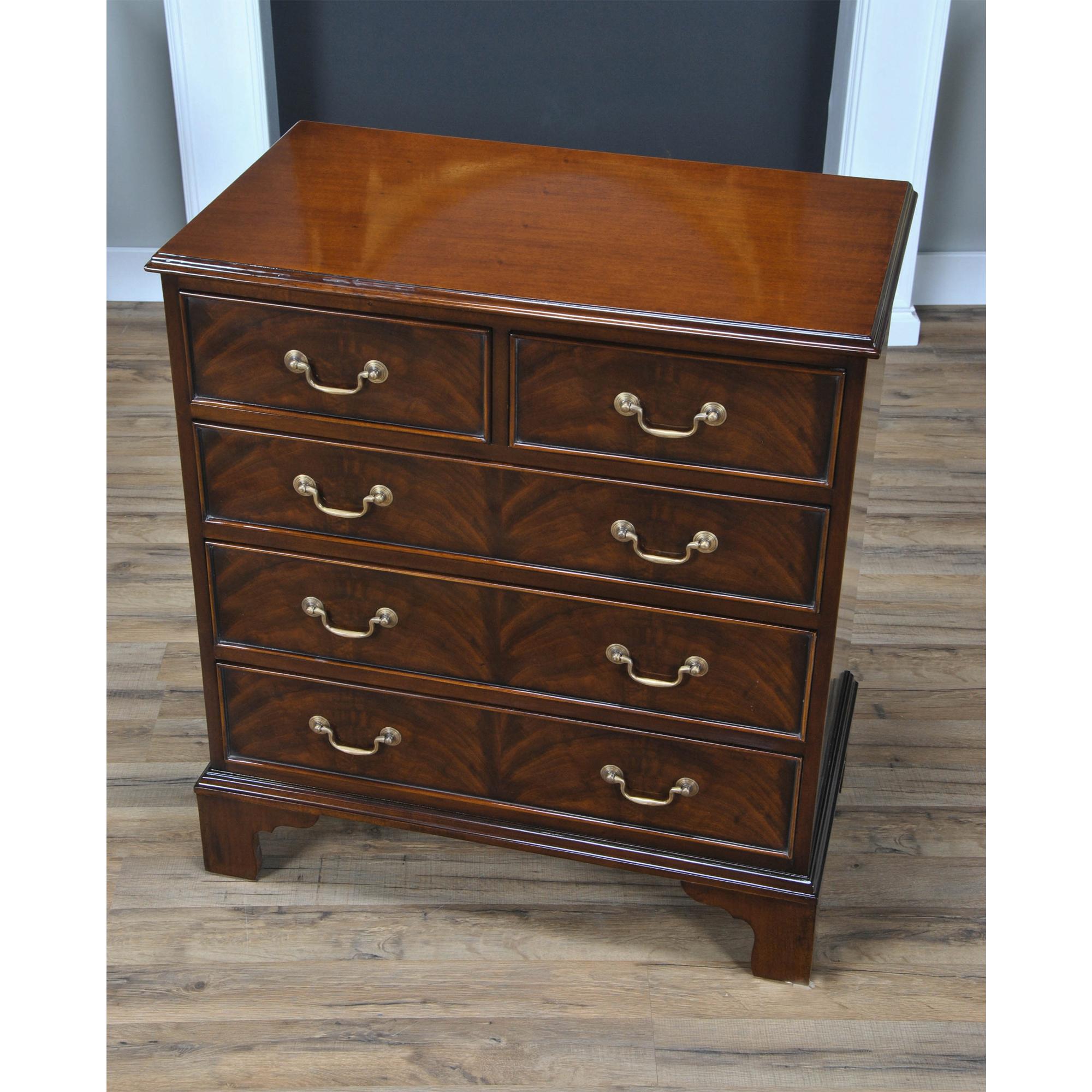 Based on an antique English chest of drawers this high quality Mahogany Bachelors Chest is both versatile and attractive in appearance. The shaped top rests over the two half width drawers, over top three full size graduated drawers all constructed