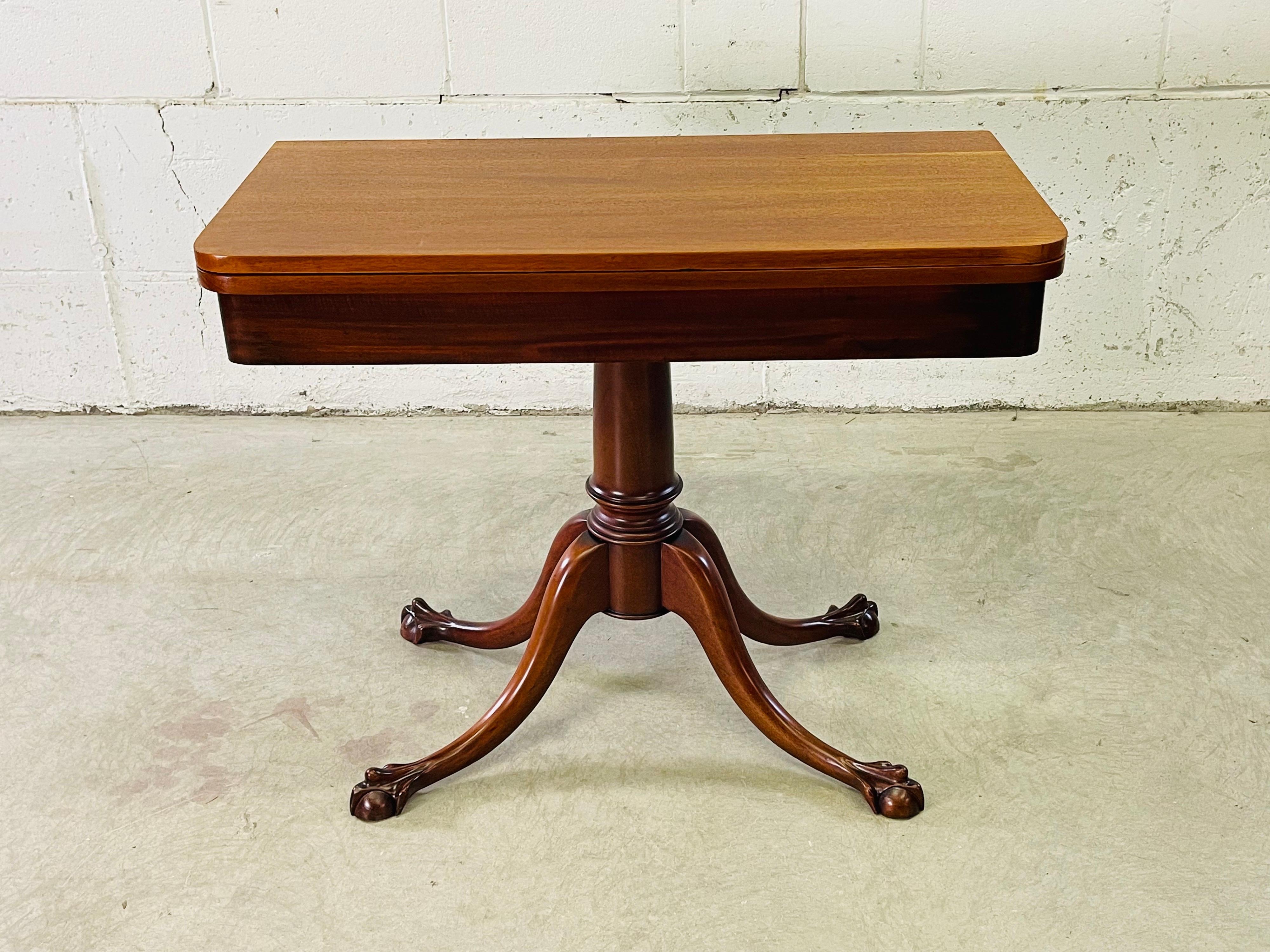 Vintage 1930s solid mahogany ball and claw foot game table. The table closes to be a rectangular side table and opens to be a square table. Can be used for more then games. Table does have storage inside. Fully open the table measures 36”W x 36”L.