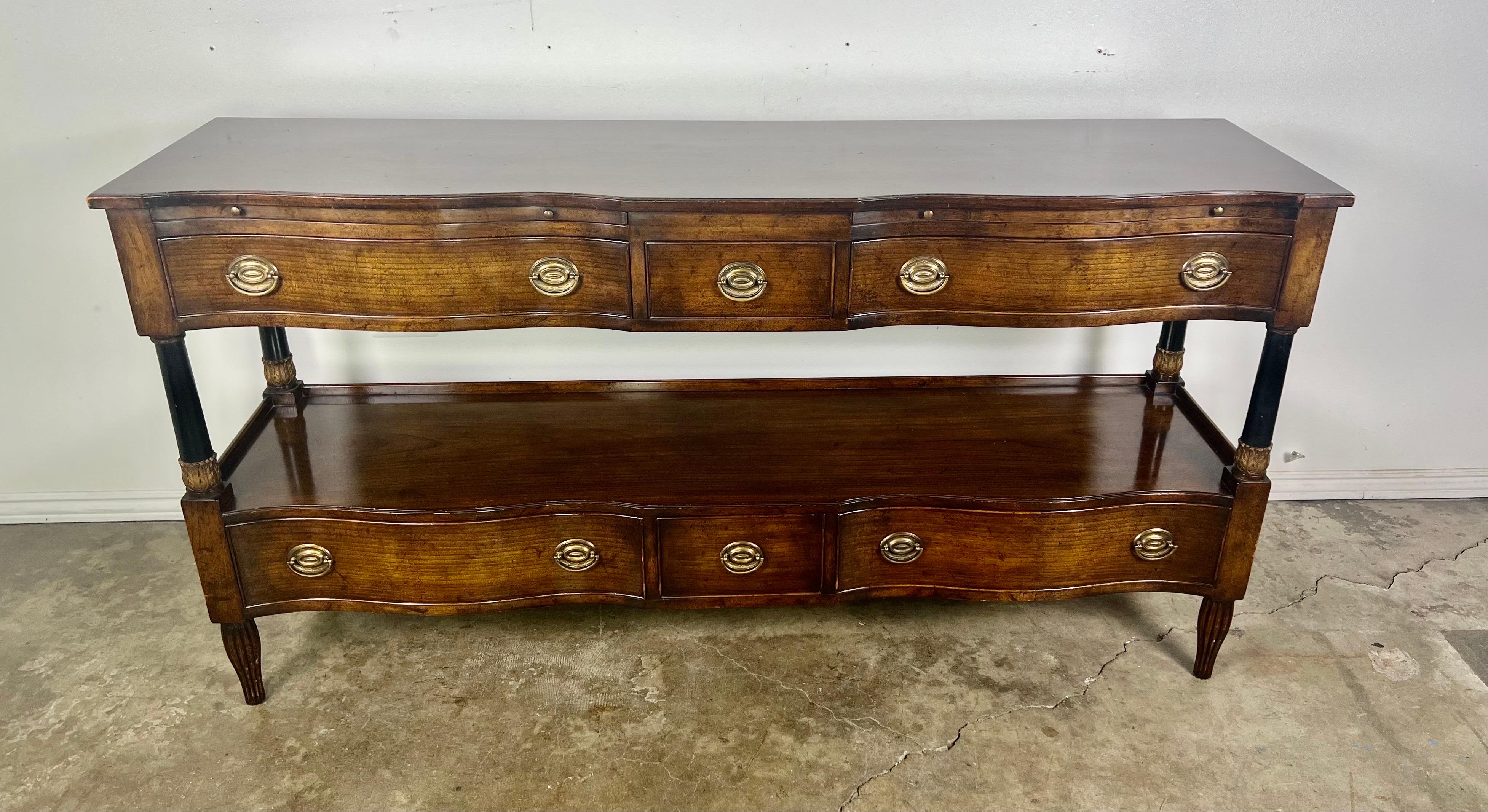 A mahogany sideboard tagged by the Beacon Hill, Old Colony Collection. This piece is fashioned out of beautiful flame mahogany with a glossy finish and features ebonized columns with giltwood acanthus leaf detail. Additional features include five
