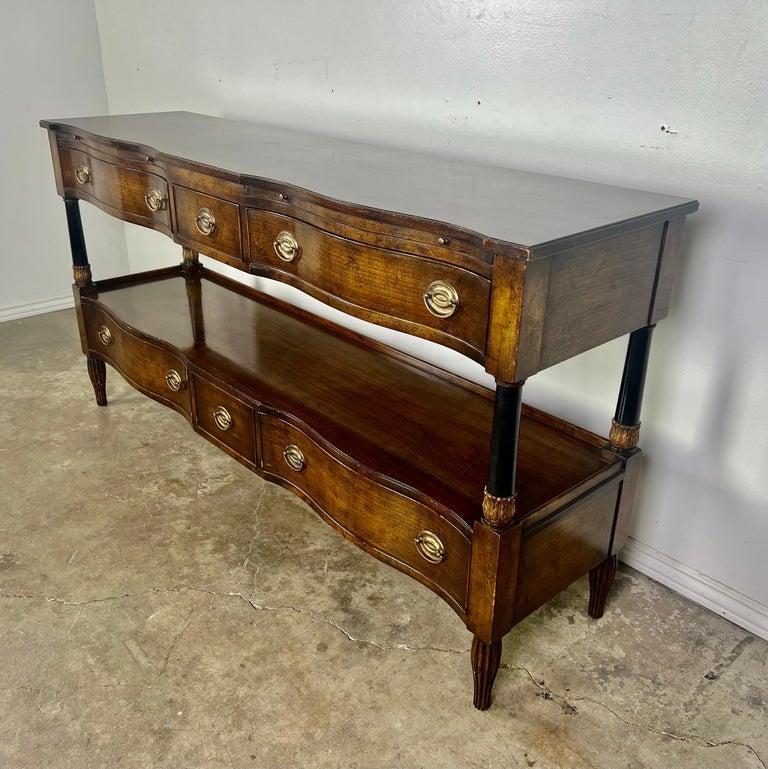A mahogany sideboard tagged by the Beacon Hill, Old Colony Collection. This piece is fashioned out of beautiful flame mahogany with a glossy finish and features ebonized columns with giltwood acanthus leaf detail. Additional features include five