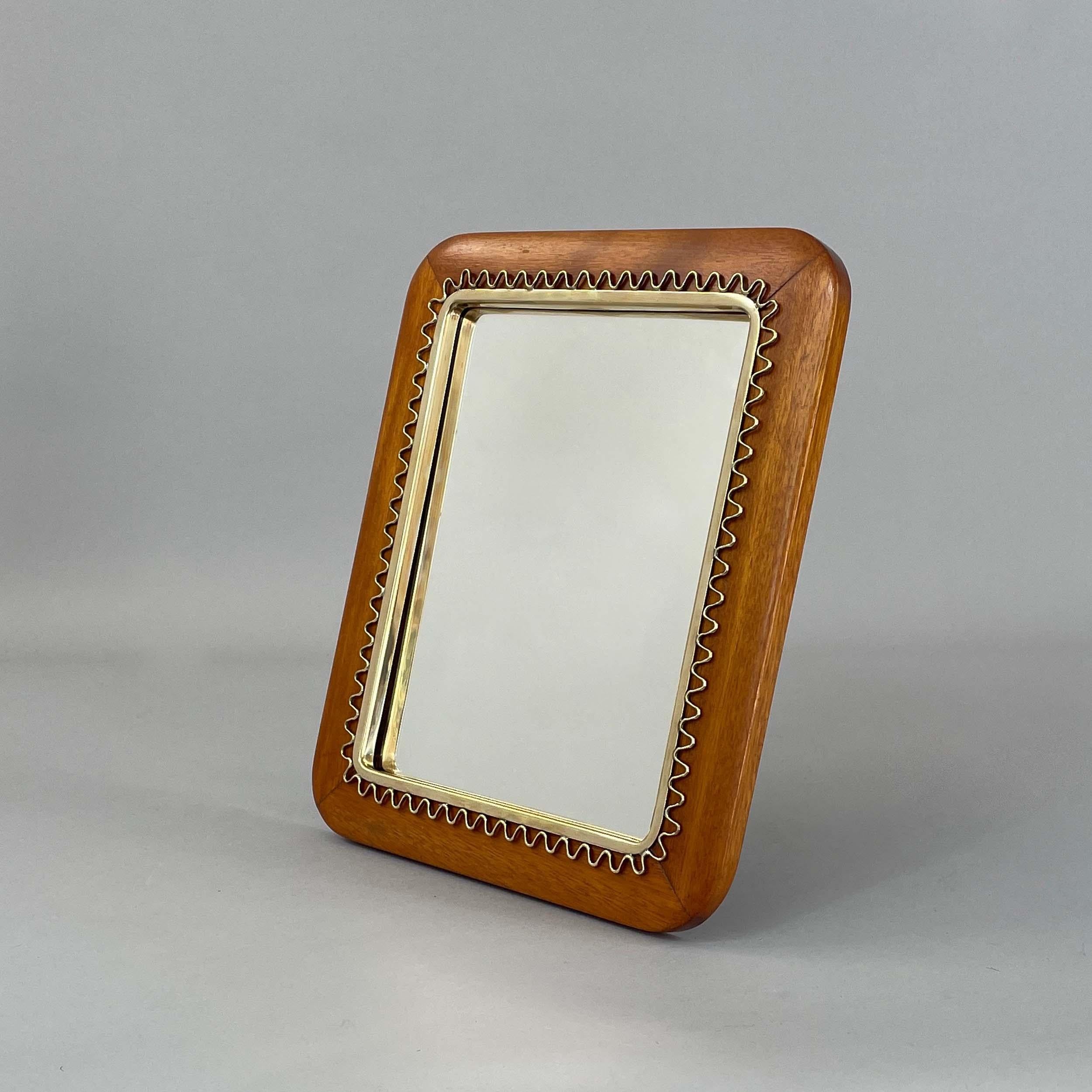 Dieser elegante moderne schwedische Tischspiegel wurde in den 1940er Jahren entworfen und hergestellt.

Der Rahmen ist aus reichem Mahagoniholz gefertigt, das seine natürliche Maserung und seinen warmen Farbton zur Geltung bringt. Der rechteckige