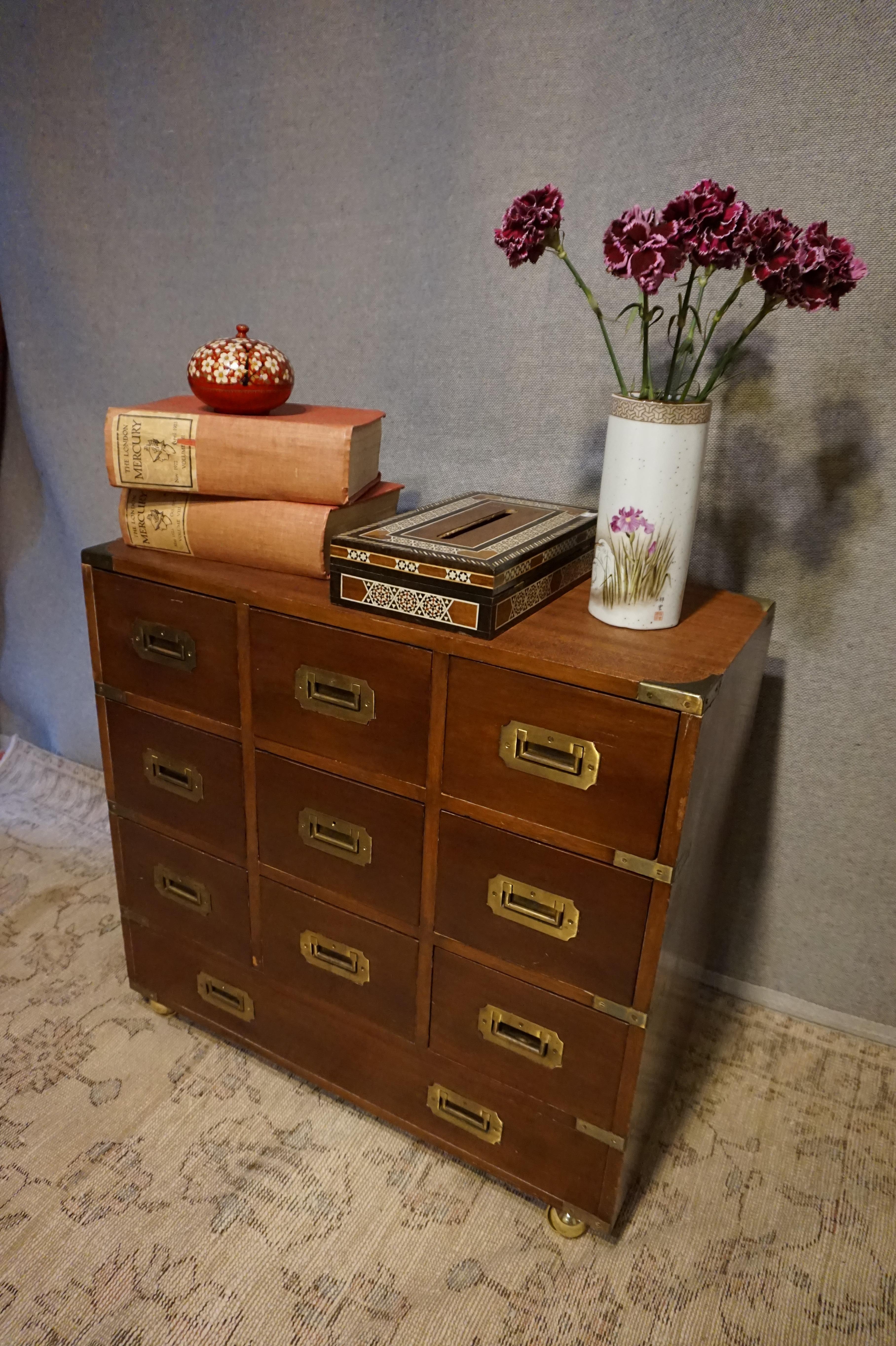 English mahogany Campaign storage chest on casters in good condition with 10 dovetailed drawers circa 1910-1920. Brass handles and compact size. Good overall condition. Exudes craftsmanship.

  