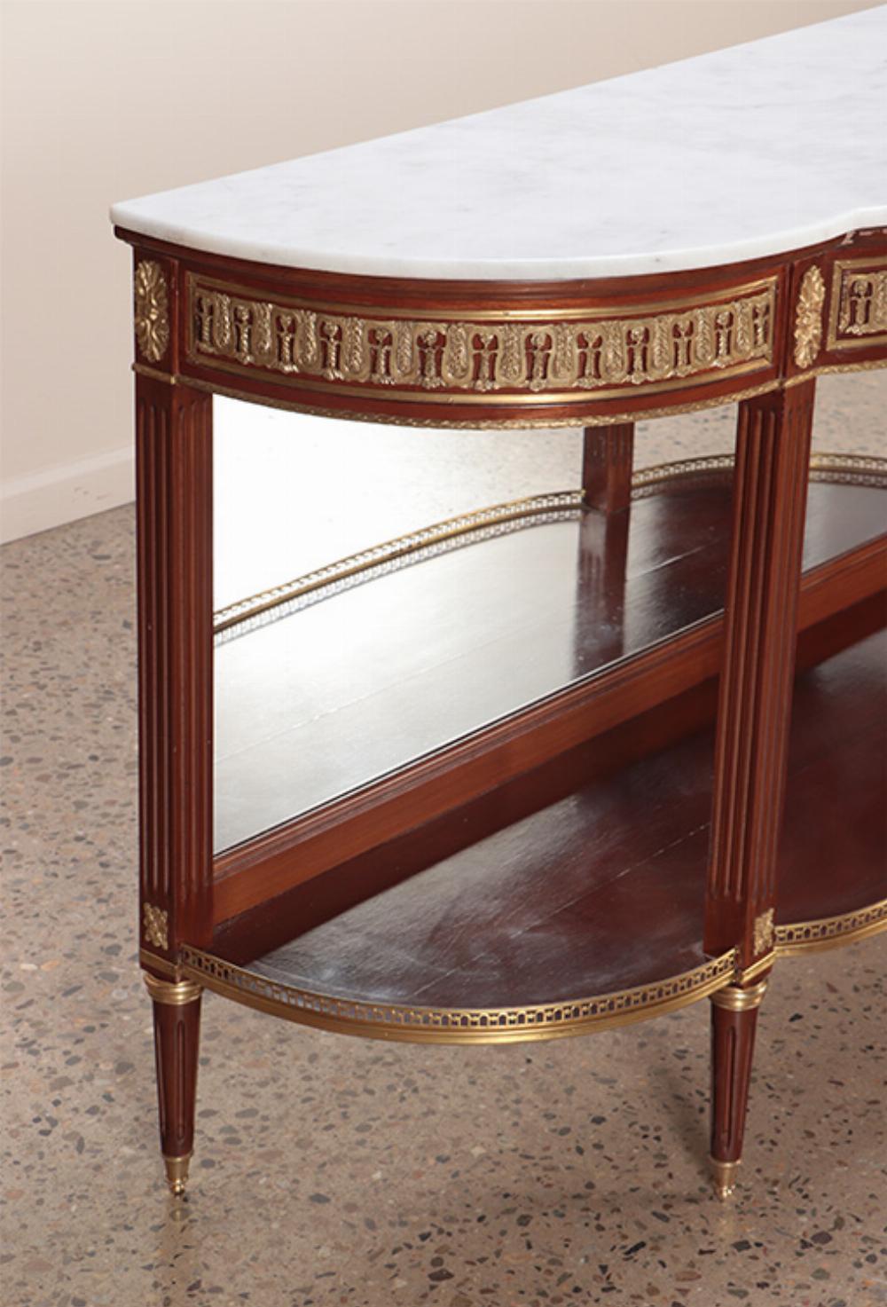 Mahogany bronze mounted Louis XVI style marble top console table with mirrored back.