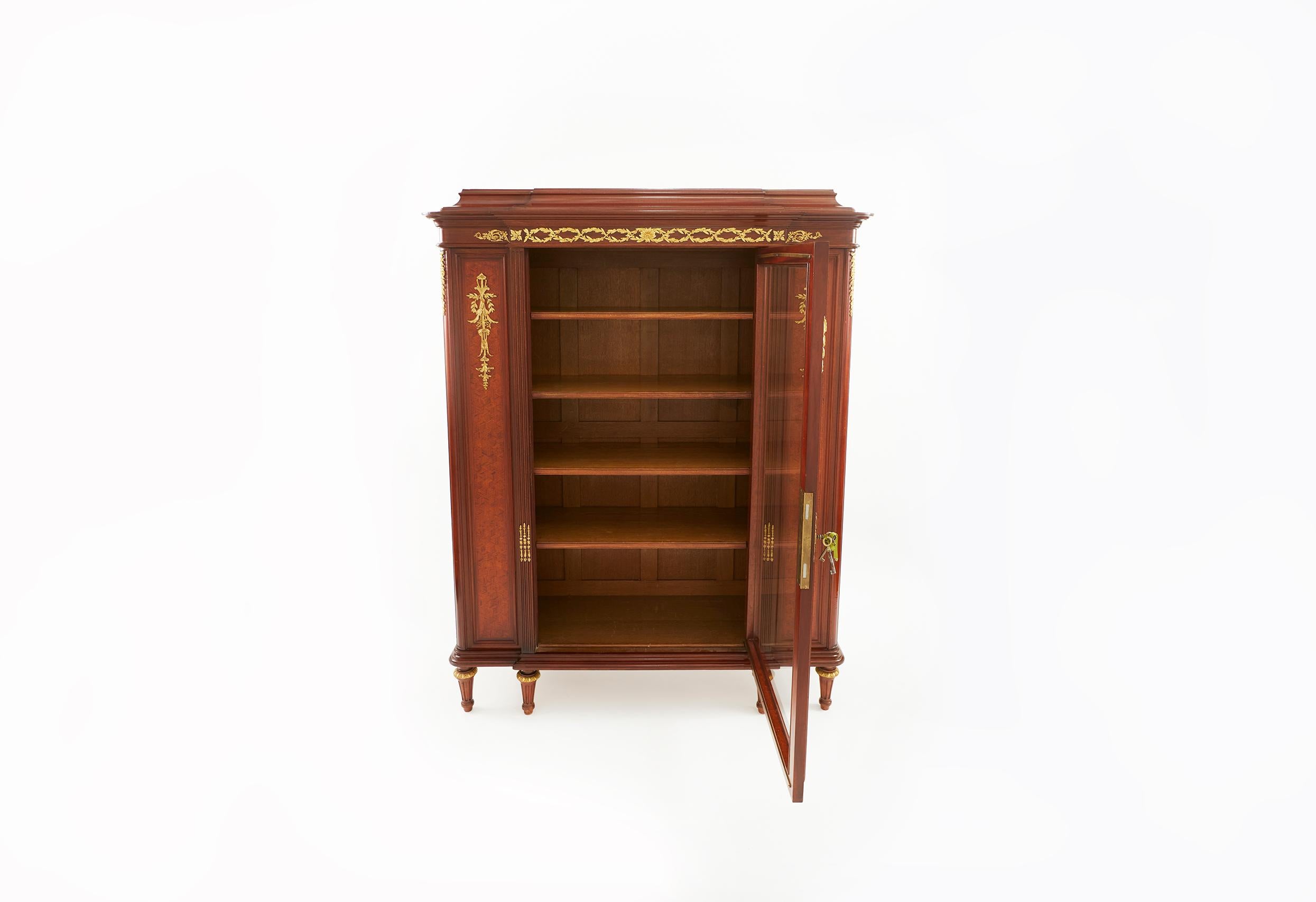 Mahogany bronze mounted detail parquetry / breakfront display cabinet / vitrine with four wooden shelves , supported by six tapering reeded legs . The cabinet / vitrine is in good condition . Minor wear consistent with age / use . The parquetry