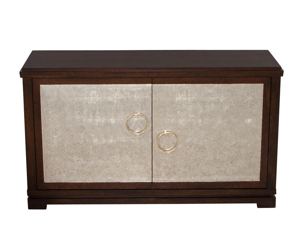 Mahogany buffet cabinet with champagne leafed doors by Jaques Garcia for Baker Furniture. Beautiful transitional design with rich mahogany woods. Composed of 2 large silver leafed doors with champagne finish overtop. Interior cabinet has height