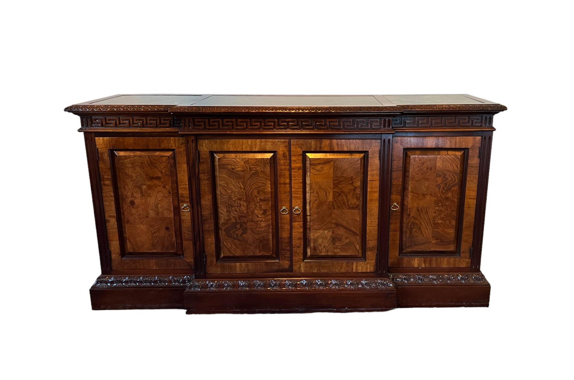 Offering a Mahogany Buffet/Credenza with green Marble Top Inset by Hekman.

The buffet features the classic Greek key design along the top apron. The interior features two levels for storage and a lockable drawer (original key included as