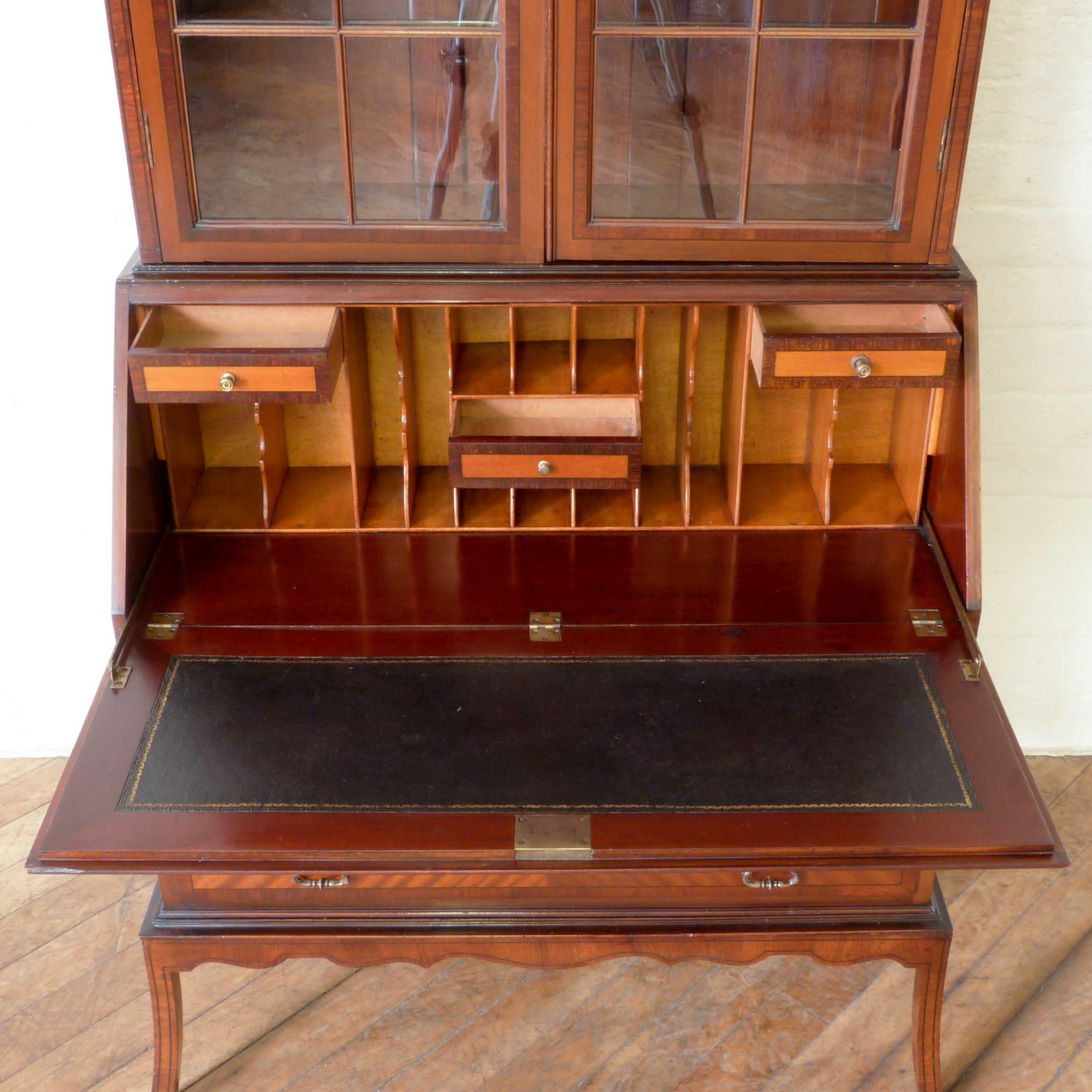 This is an elegant mahogany bureau bookcase from the Edwardian period and very much in the style of George Hepplewhite from the late 18th century. Crossbanded throughout in rosewood and ebony with a wonderful geometric inlay to the fall of the