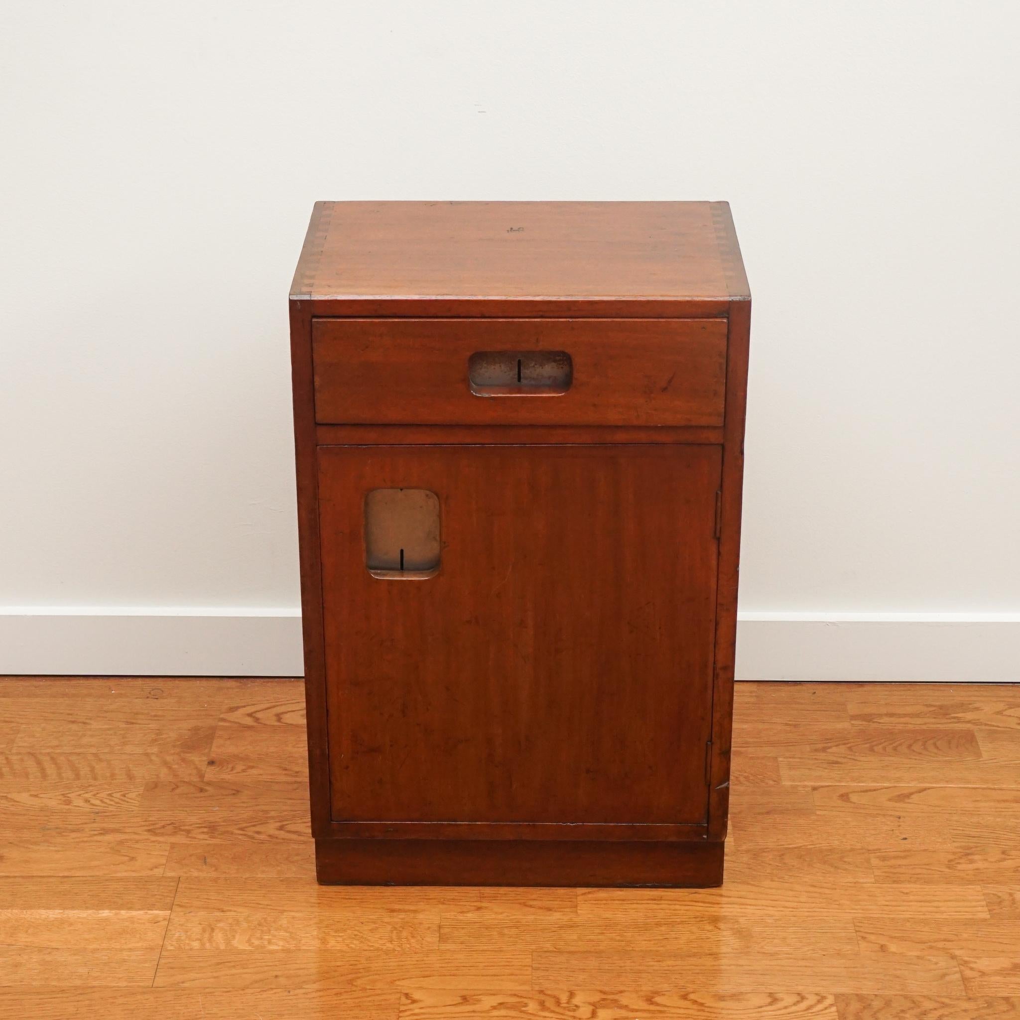 This handsome mahogany cabinet with single door and drawer is as practical today as it was when it was first made in the 1950s. The cabinet has been gently restored to enhance the rich mahogany finish. The brass hardware is original to the piece. A