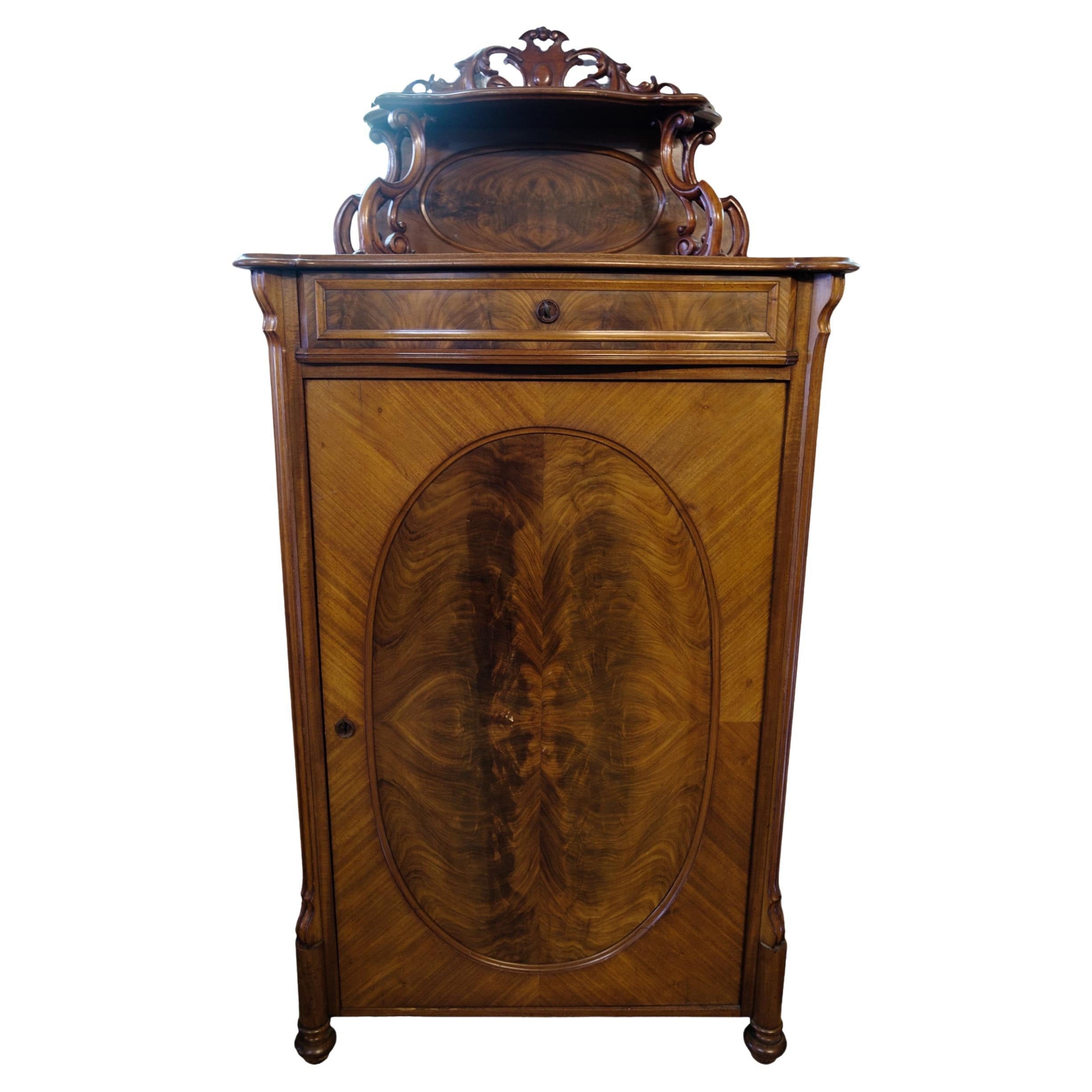 Mahogany cabinet decorated with wood carvings and intarsia from around the 1880s For Sale