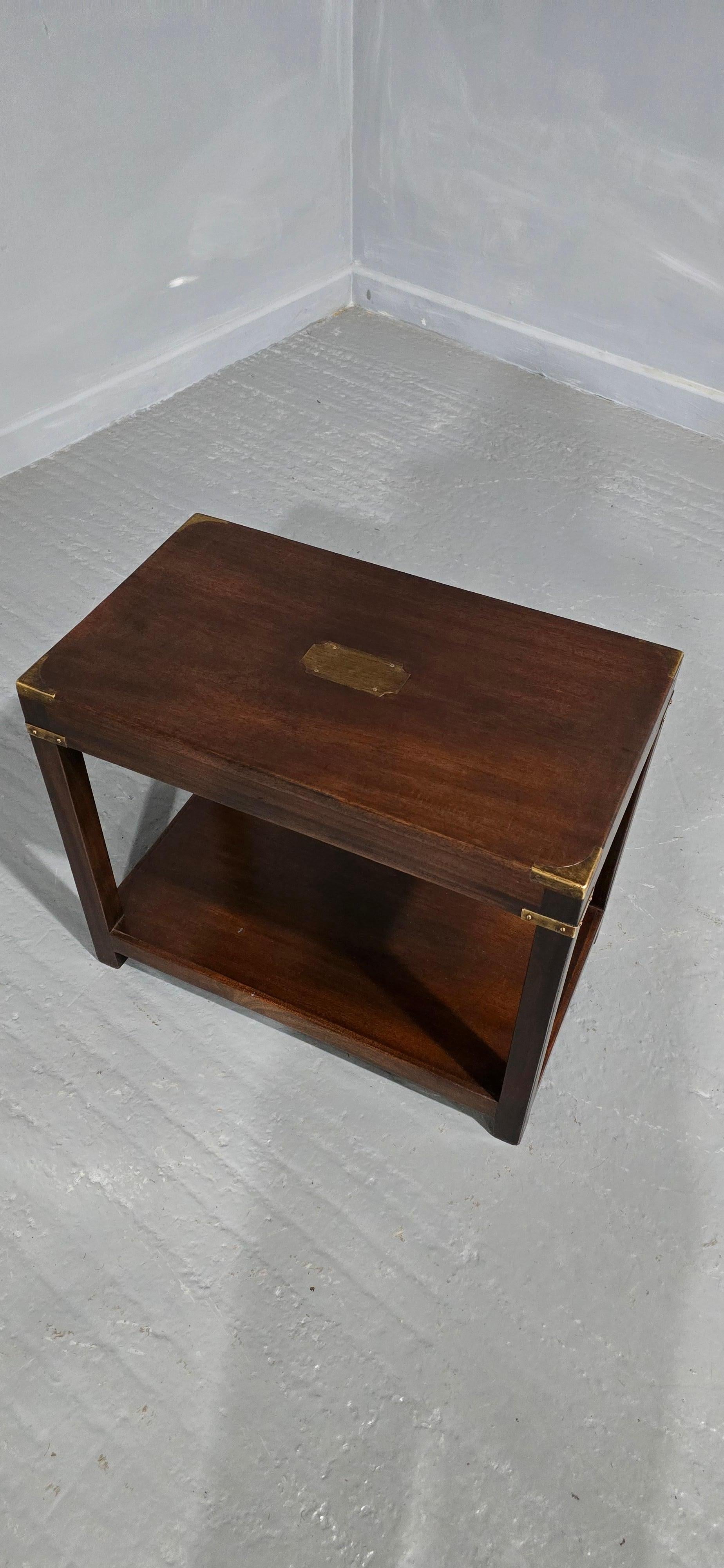 A  very good mahogany two tier campaign lamp table with inset brass plaque and corners, in overall very good condition.





