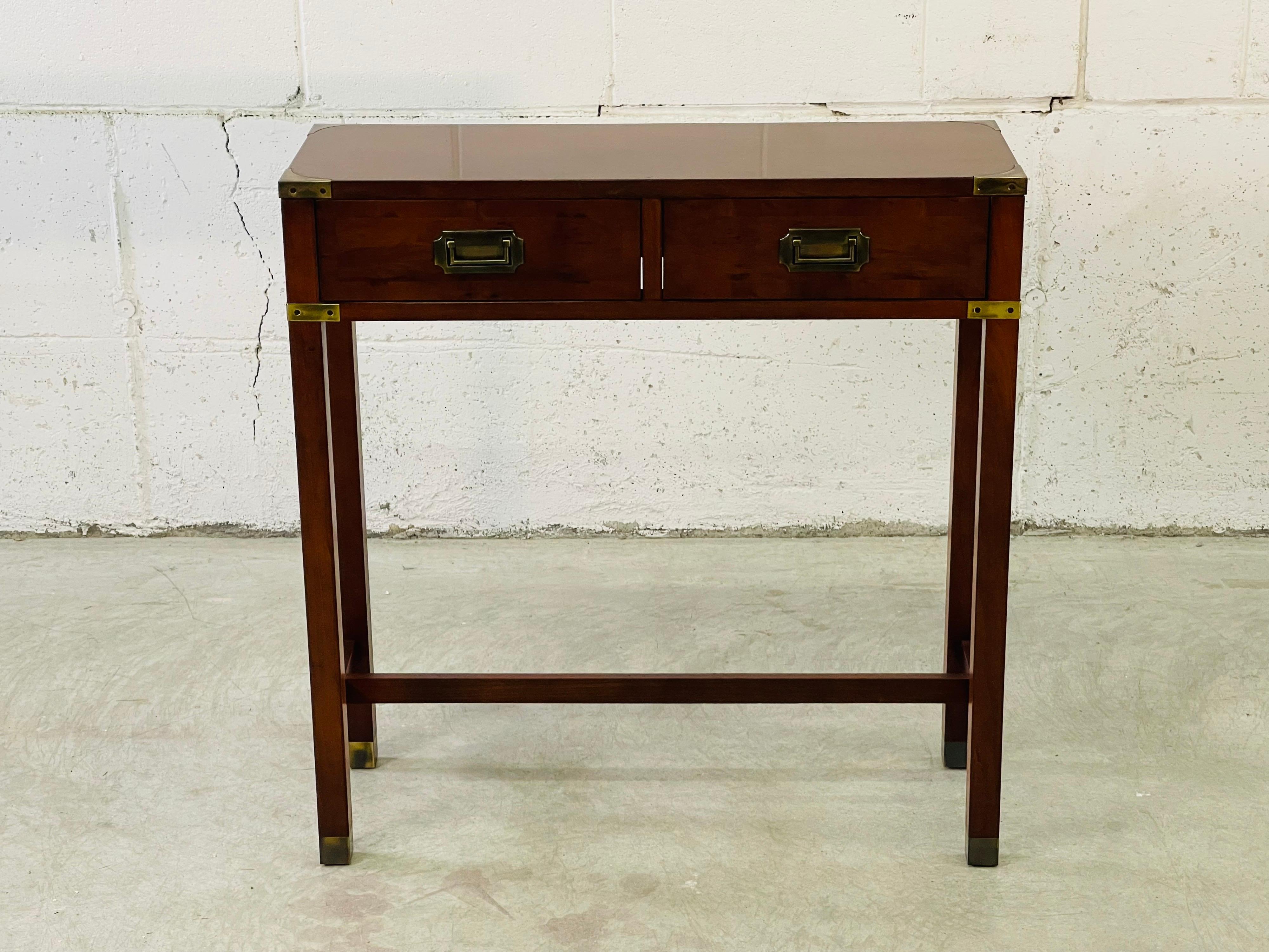 Vintage mahogany campaign style two drawer console table by Hekman Furniture. The table has very nice brass accents and drawer pulls. Great for a small space. Marked in the drawer.