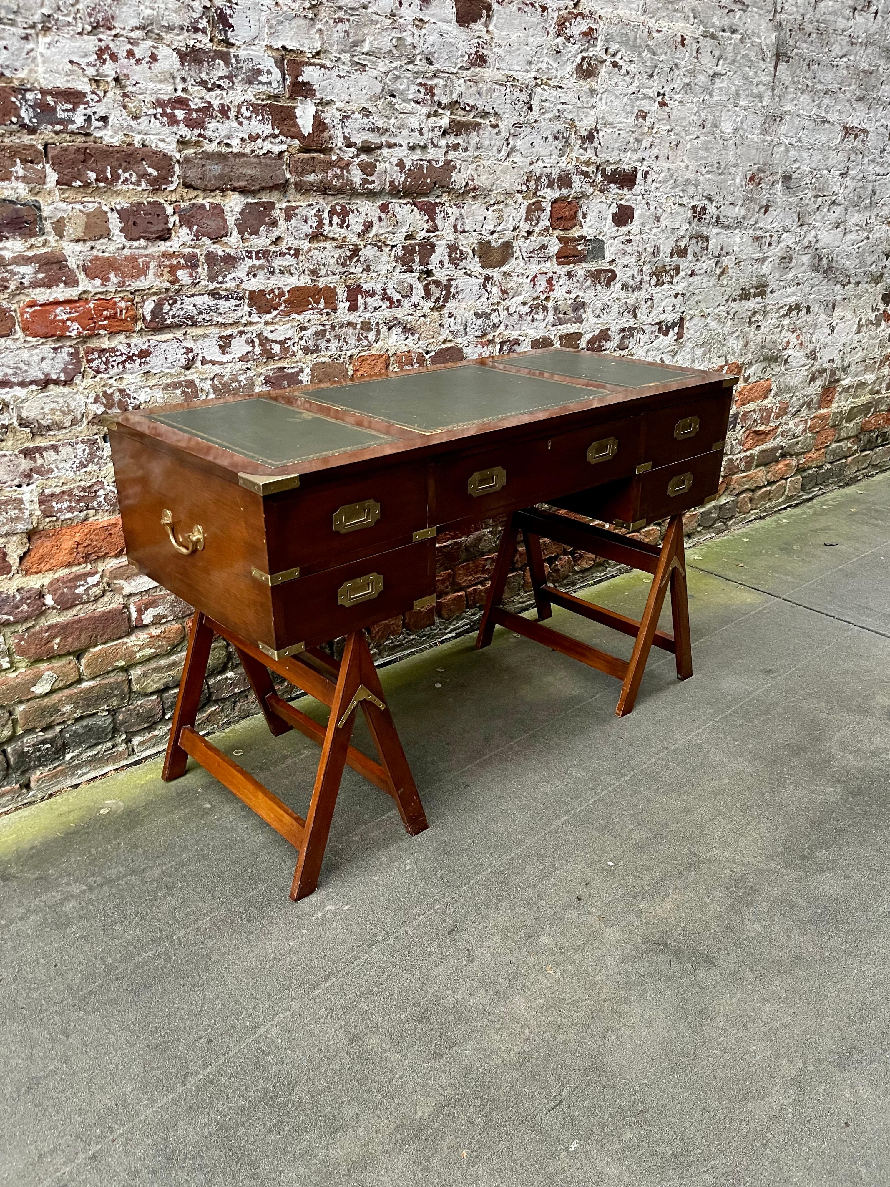 Mahogany campaign style desk on stand with leather writing surface.