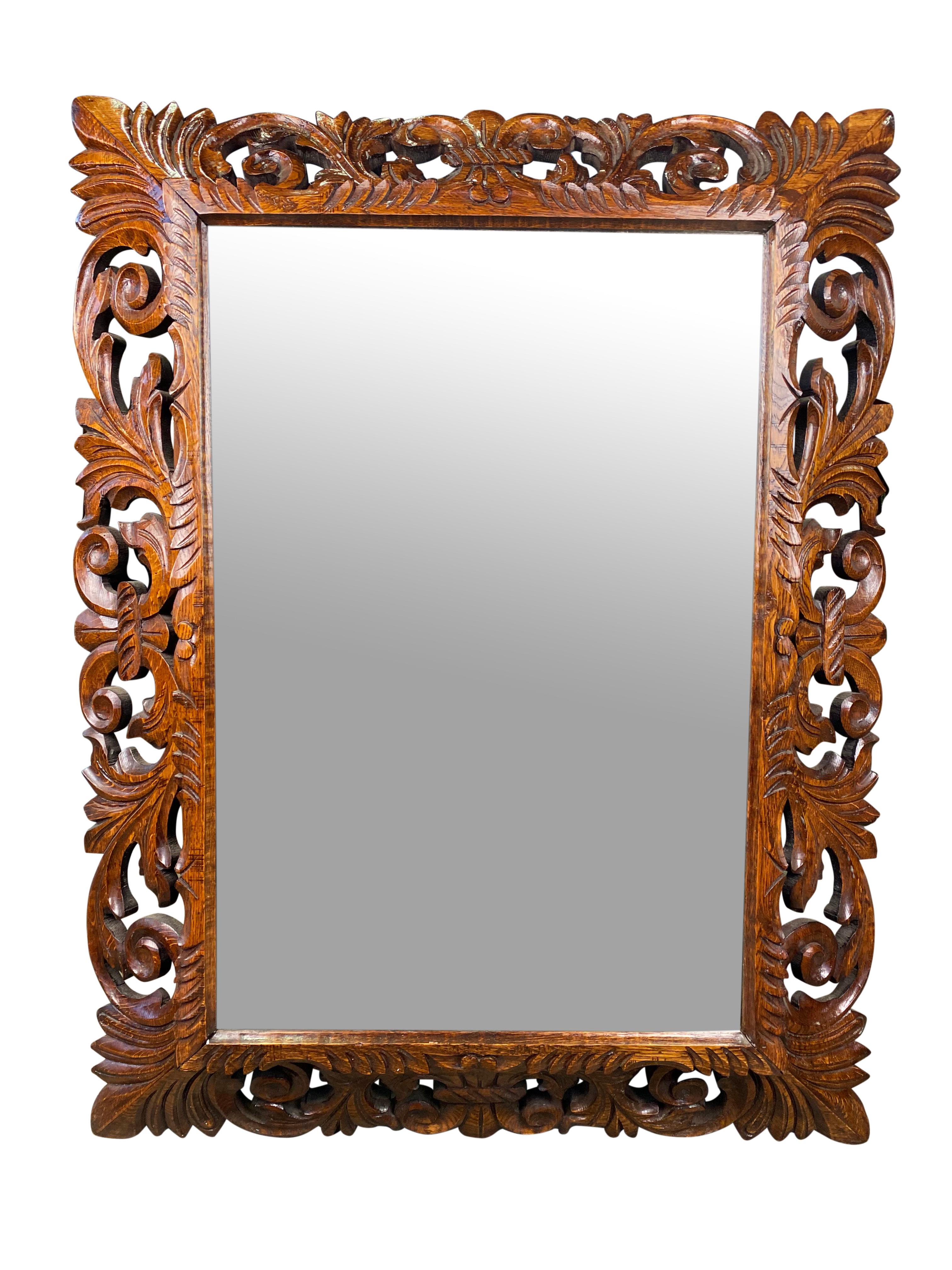 Extravagantly carved mahogany mirror in rectangular dimension. A lovely grain pattern runs symmetrically across the wood surrounding a very generously sized fitted mirror. 

Dimensions (cm)
107H/80W/79D