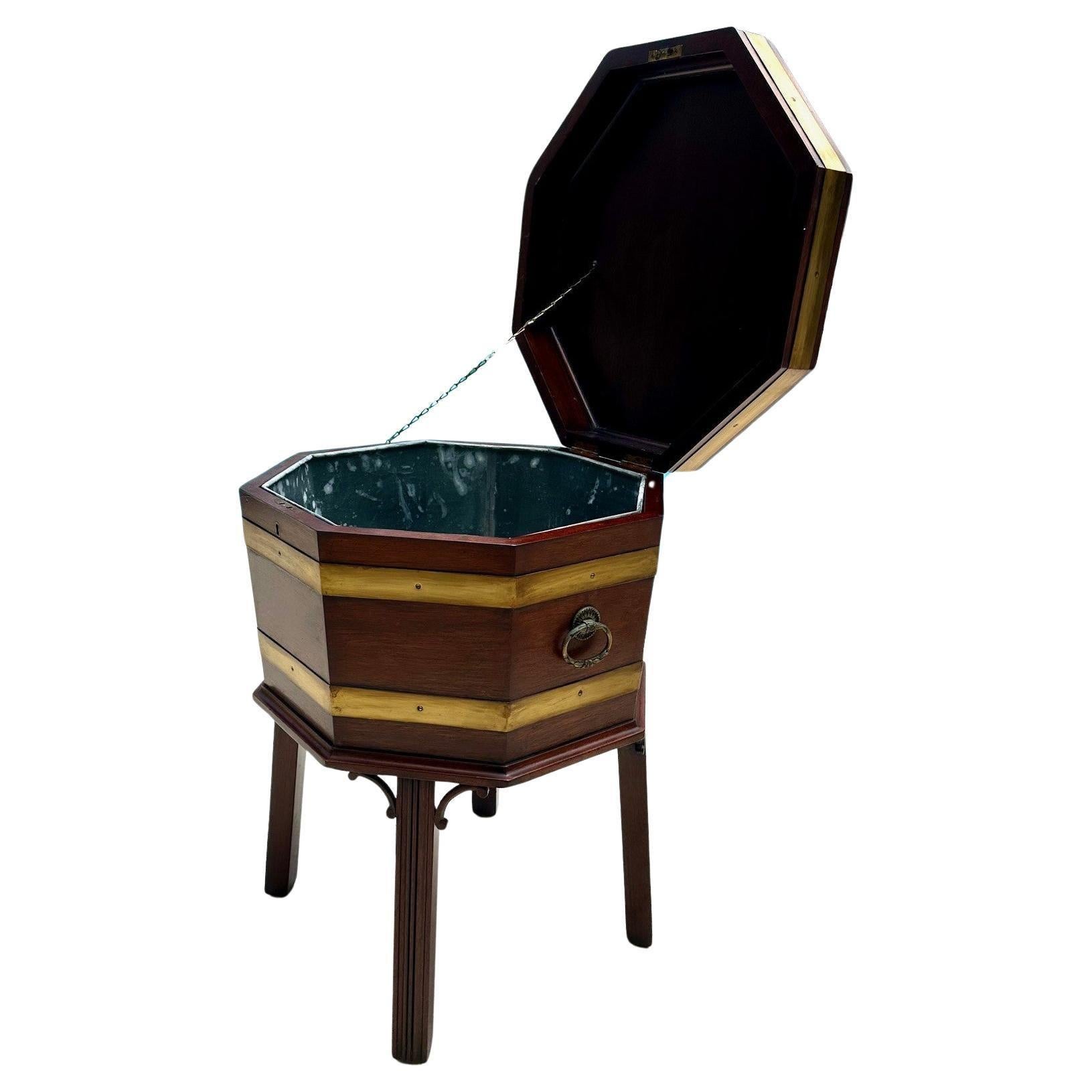 Mahogany Cellarette Wine Cooler Chippendale Style 

A Chippendale style mahogany octagonal shaped wine cooler bound with traditional brass bands and fitted with brass handles and a zinc removeable liner.  It stands on 4 square shaped flared legs.